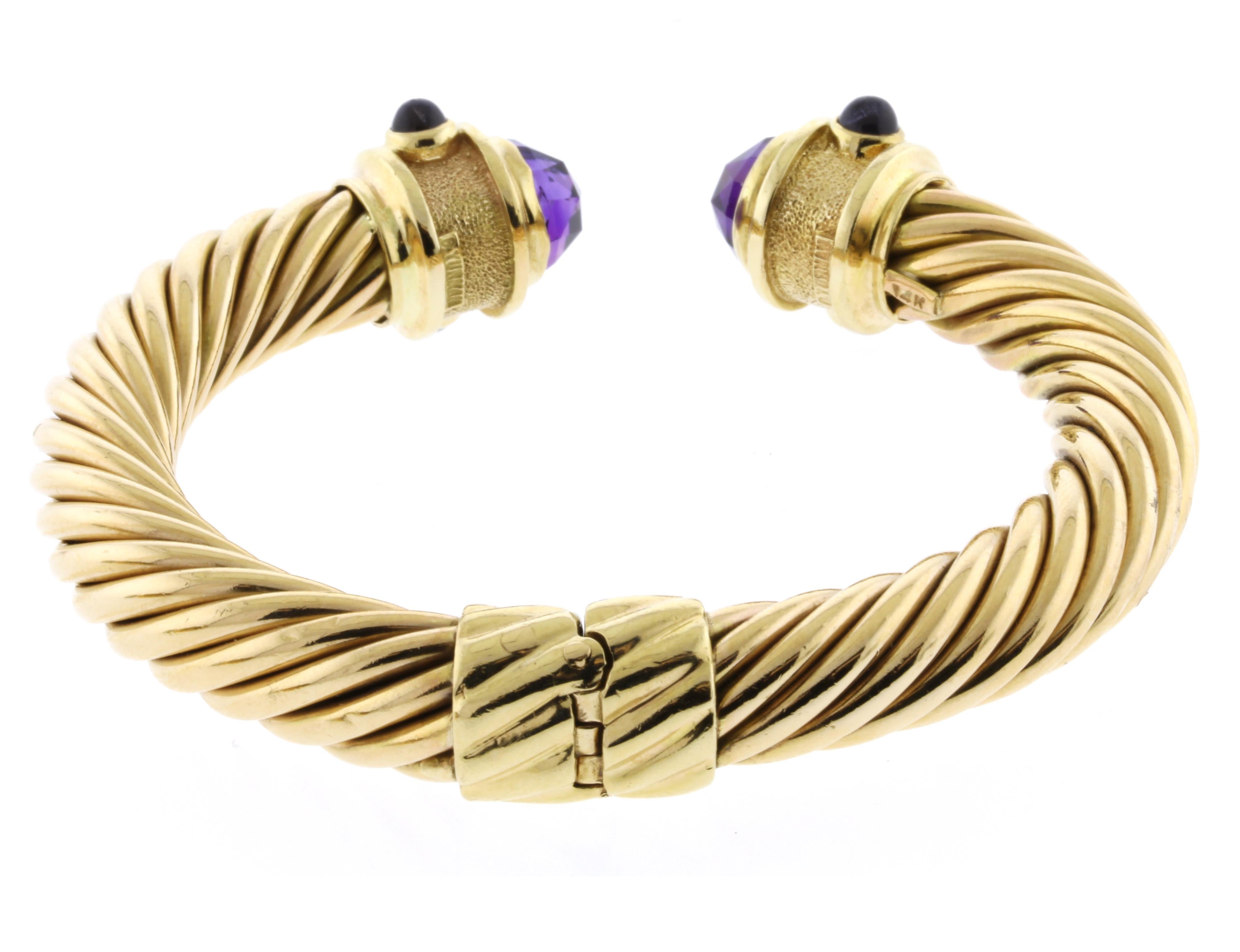  Ein ikonisches Kabelarmband von David Yurman mit Edelsteinen.
- • Designer: David Yurman
- • Metall: 14 Karat Gelbgold
- • CIRCA: Anfang der 1980er Jahre
- • Edelsteine: 2 Amethyste, 4 Cabochon-Iolithen und 2 rosa Turmaline
- • Gewicht: 49.3