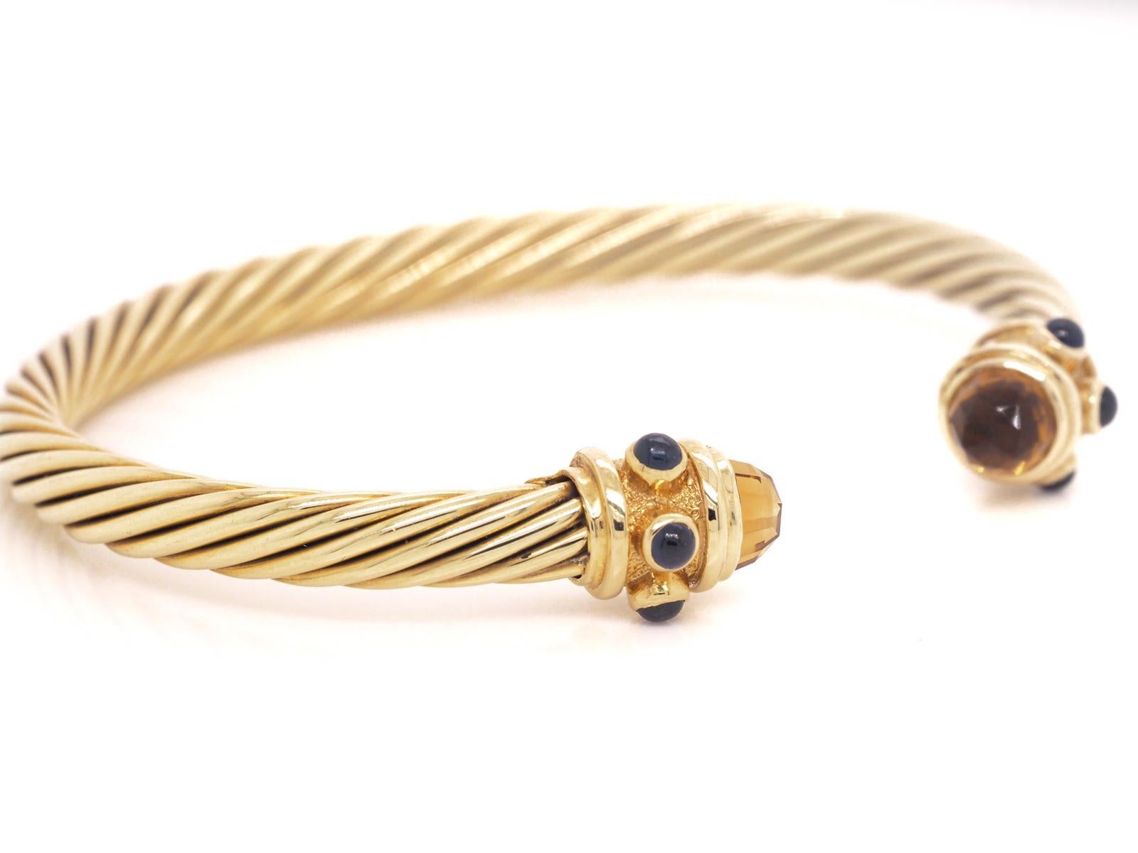 This beautiful David Yurman 14 Karat Yellow Gold Renaissance cuff bracelet was designed in their signature cable design. The cuff bracelet features cabochon sapphires and citrine. It is 5 millimeters in width and weighs approximately 16.8 grams.