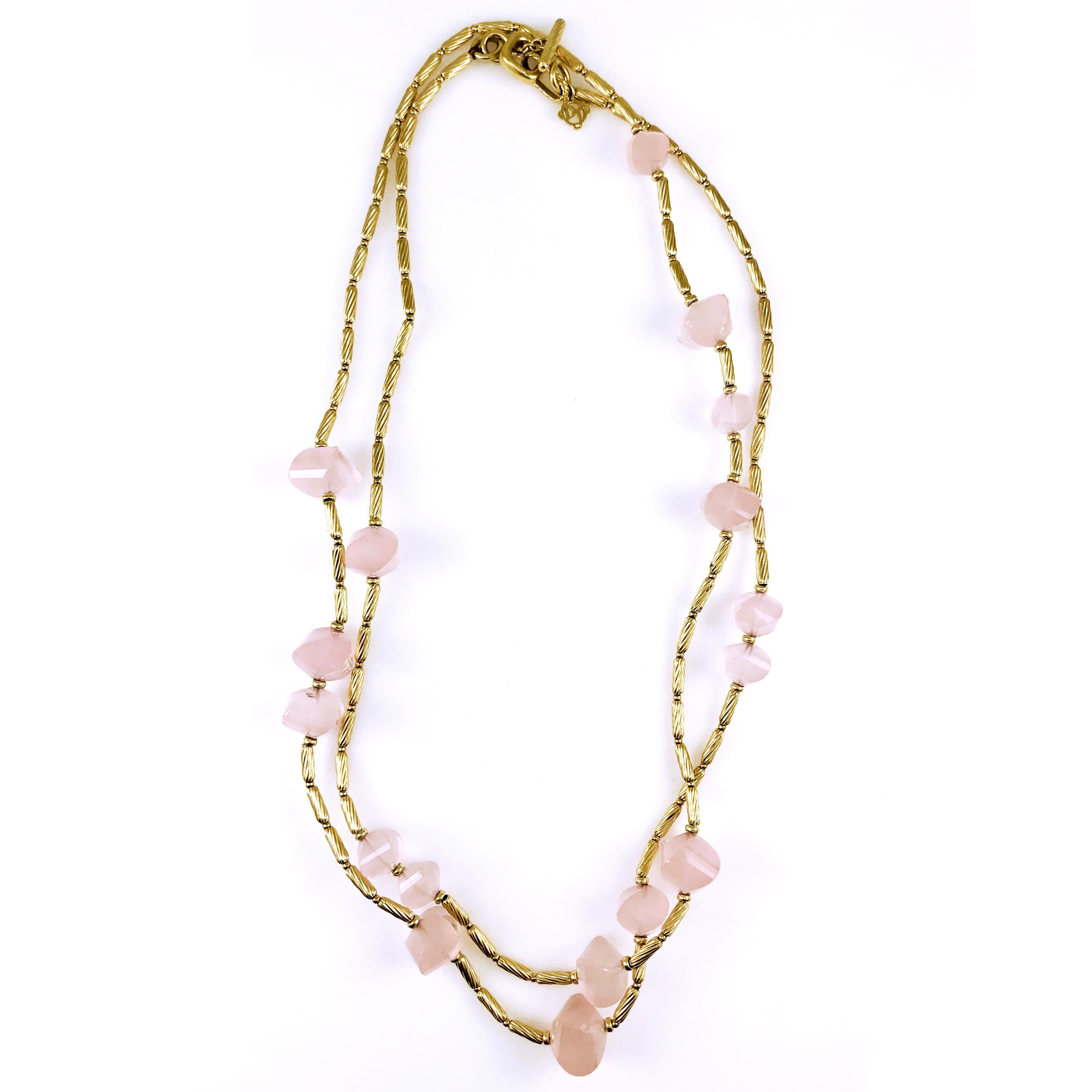 David Yurman 18 Karat Yellow Gold and Rose Quartz Necklace. The designer necklace features tubular twisted cable and round bead and rose quartz beads. The length of the necklace is 44'' and it has a toggle clasp. The faceted Rose Quartz beads range