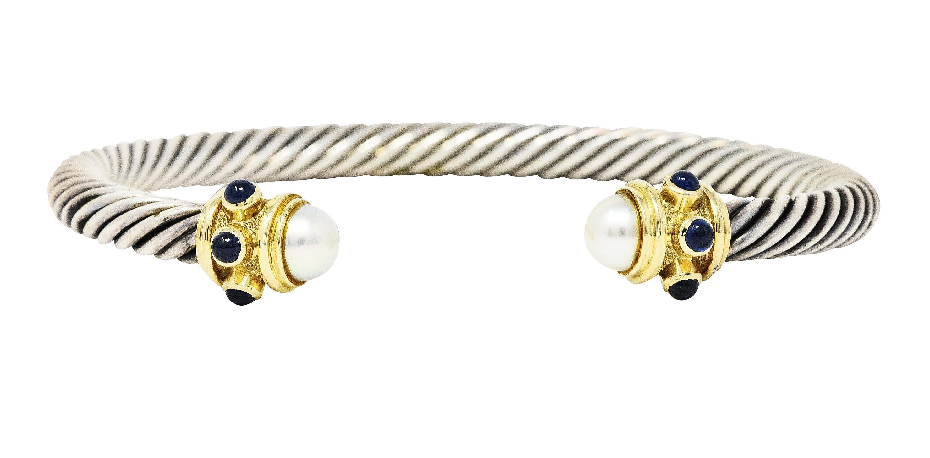 Designed as an open cuff bracelet comprised of twisting sterling silver cable 

Deeply ridged gold terminals completed by 6.0 mm round mabe pearl cabochons

Pearls are white in body color with very good luster

Accented by bezel set medium blue 2.5
