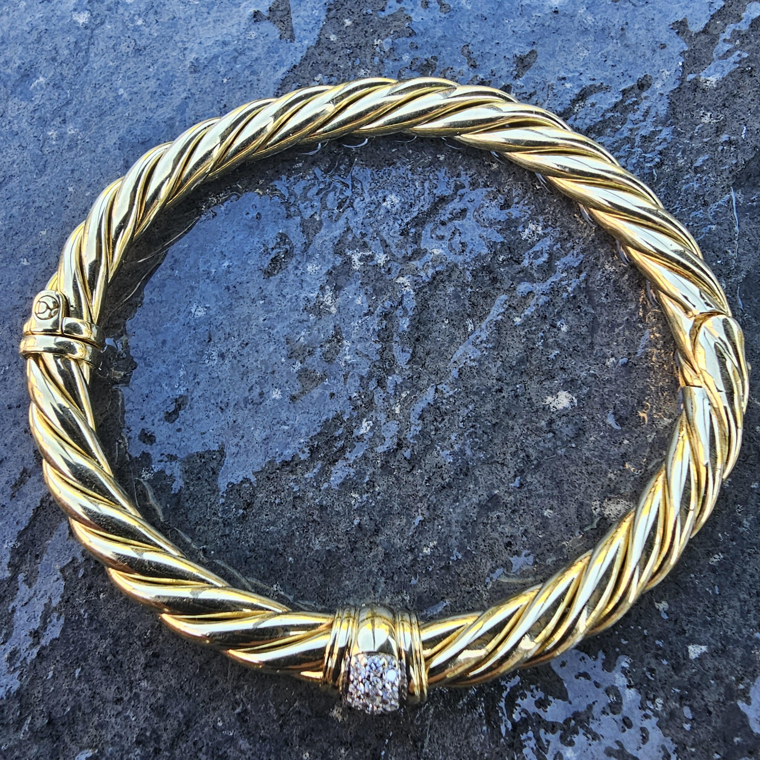 David Yurman Bracciale con cerniera scolpita in oro 18 carati con stazione centrale di diamanti incastonati.

Ti presentiamo uno splendido braccialetto bangle di David Yurman realizzato in oro 18 carati. Il bracciale presenta un design a corda