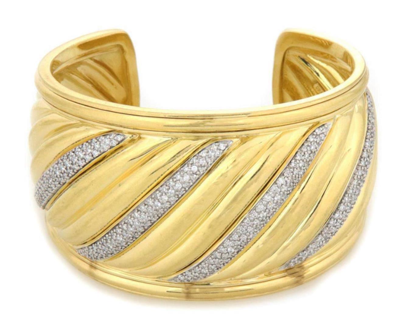 This is an authentic eye-catching cuff  bracelet by David Yurman from the Sculpted Cable collection, it is crafted from 18k yellow gold with a polished finish featuring a 41mm wide band in the cable style, the front center of the bracelet has 4 long