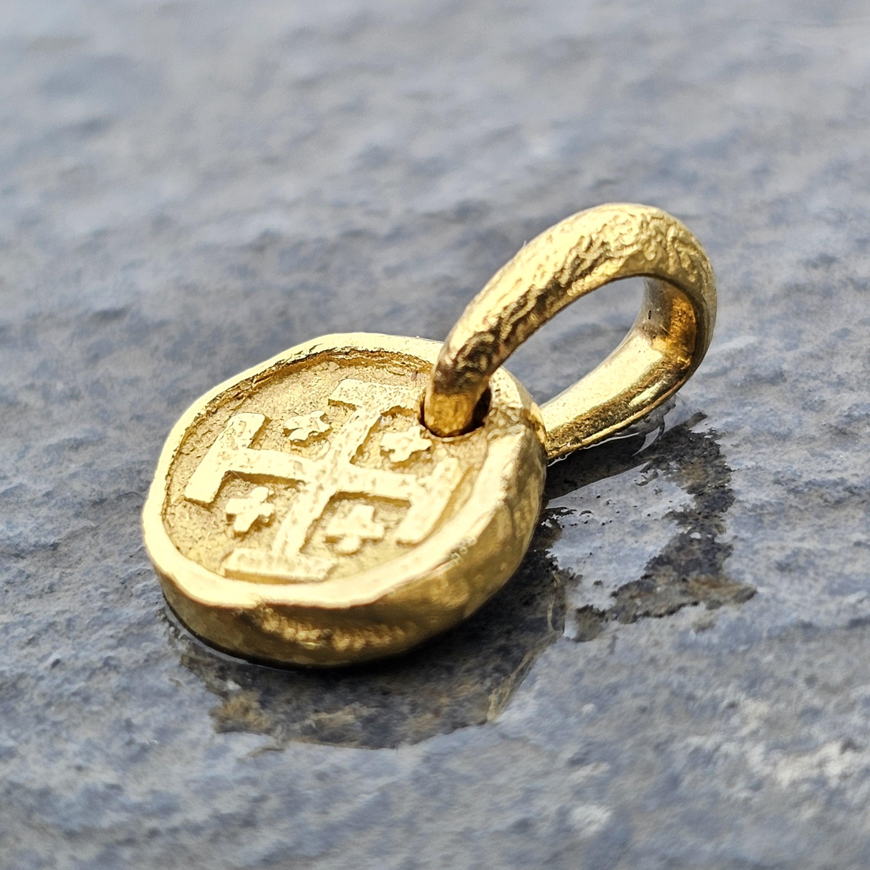 This is a David Yurman mini Shipwreck coin pendant necklace crafted from 22k yellow gold. The pendant features a textured circular design with an intricate symbol at its center.
Currently Yurman only offers an 18k gold version of this for $995. This