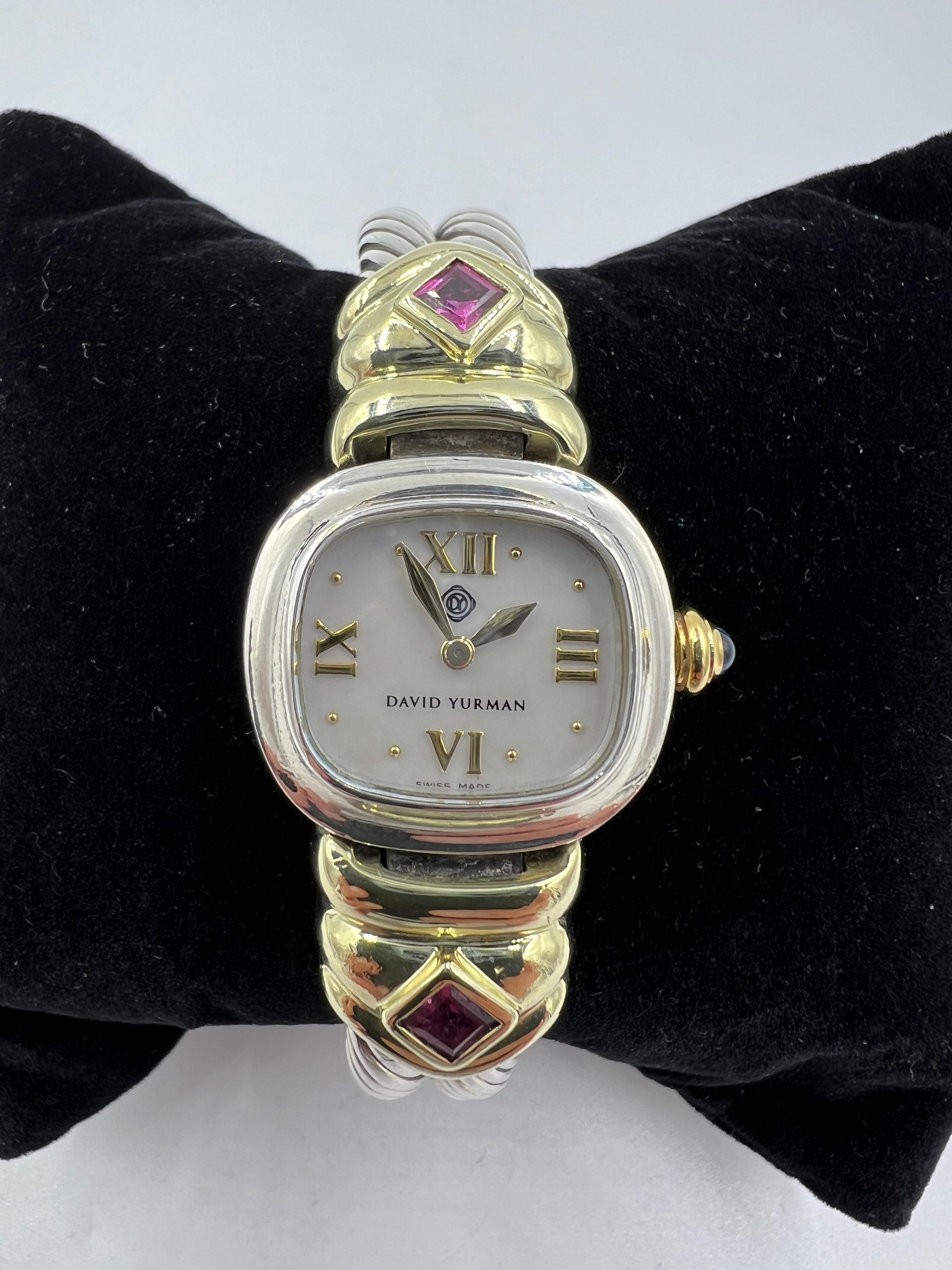 Reloj de pulsera David Yurman de plata granate y oro amarillo.

Este reloj de pulsera David Yurman de plata de ley y oro amarillo está engastado con 2 granates de rodolita de talla cuadrada. La esfera tiene un bello rostro de nácar blanco.