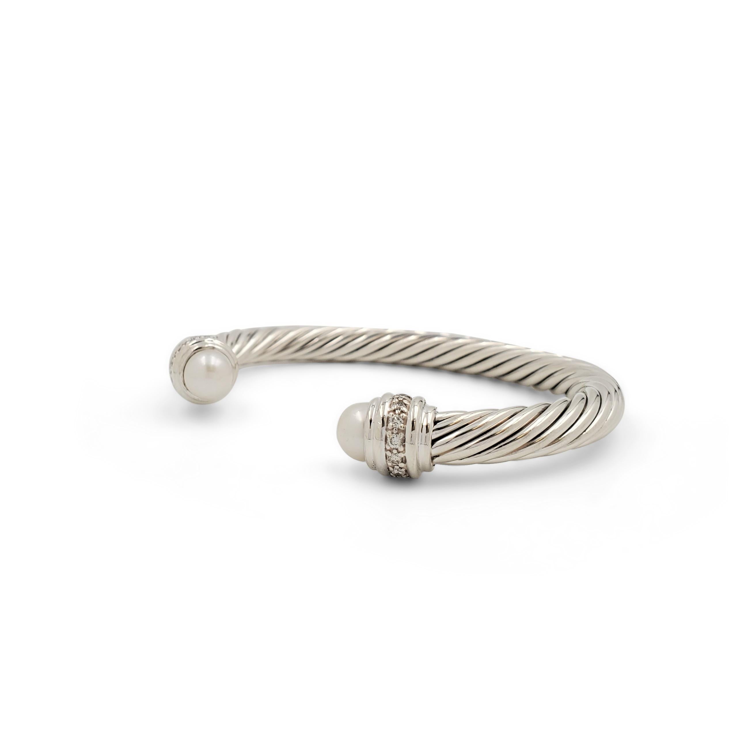 Authentic David Yurman bangle crafted in sterling silver. The bracelet is set with two pearls and approximately 0.25 carats of round brilliant cut diamonds (I-J color, VS-SI clarity) on either side of their iconic split bangle. Signed David Yurman,