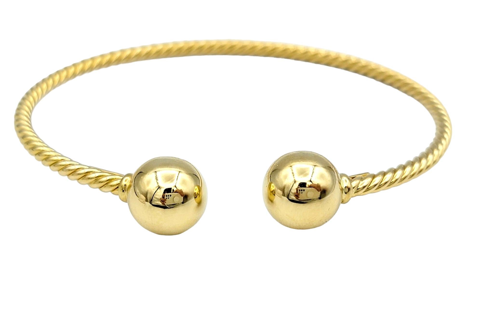 This gorgeous David Yurman cuff bracelet, crafted in lustrous 18 karat yellow gold, is a stunning example of timeless elegance and craftsmanship. Its band features a mesmerizing twisted gold pattern, adding depth and texture to the design. This