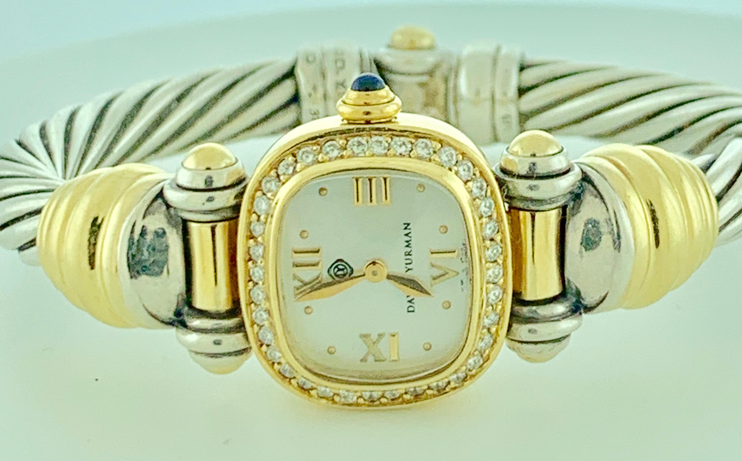David Yurman Sterling silver and 18 karat 750 yellow gold braided sterling cable bangle watch with diamond bezel, and cabochon cut sapphire crown. 50 grams. Stamped on the back 