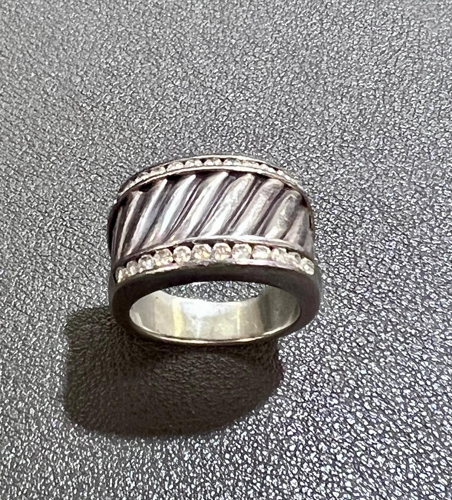 Magnifique bague David Yurman Cigar Band avec son design classique en forme de câble et deux rangées de diamants d'accentuation
Largeur de la bande = 13,5 mm
Taille 5.5
Masse totale = 9 gramme

Référence DB-1038 (JC3/6/25).