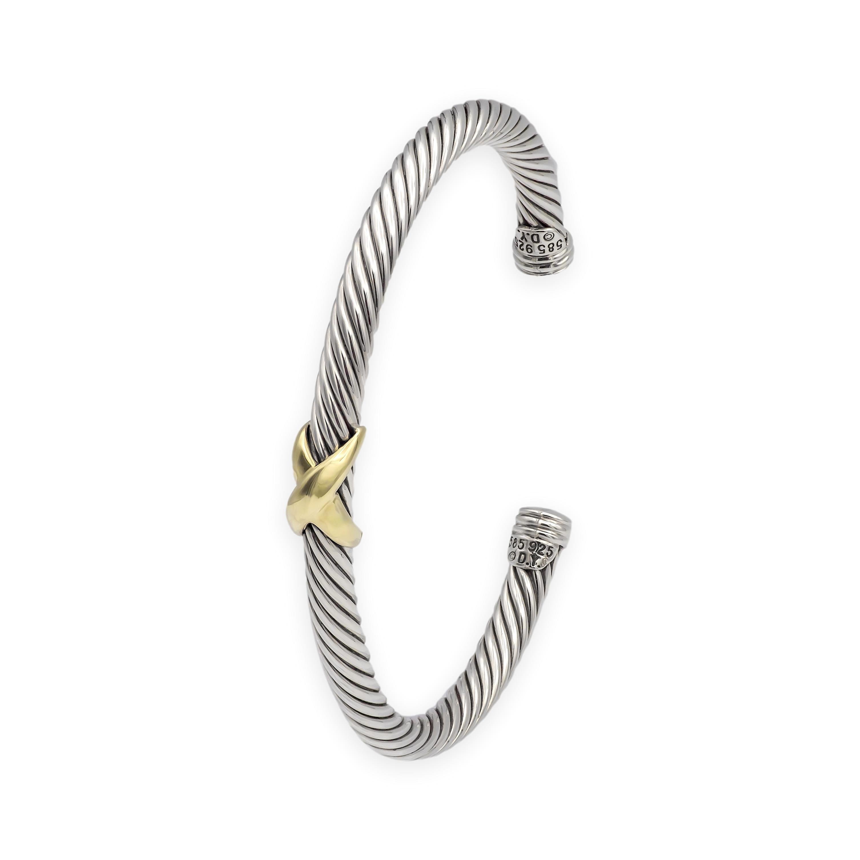Esta intemporal pulsera brazalete David Yurman presenta el icónico diseño de cable trenzado de la marca en plata de ley con un atrevido detalle cruzado en forma de 