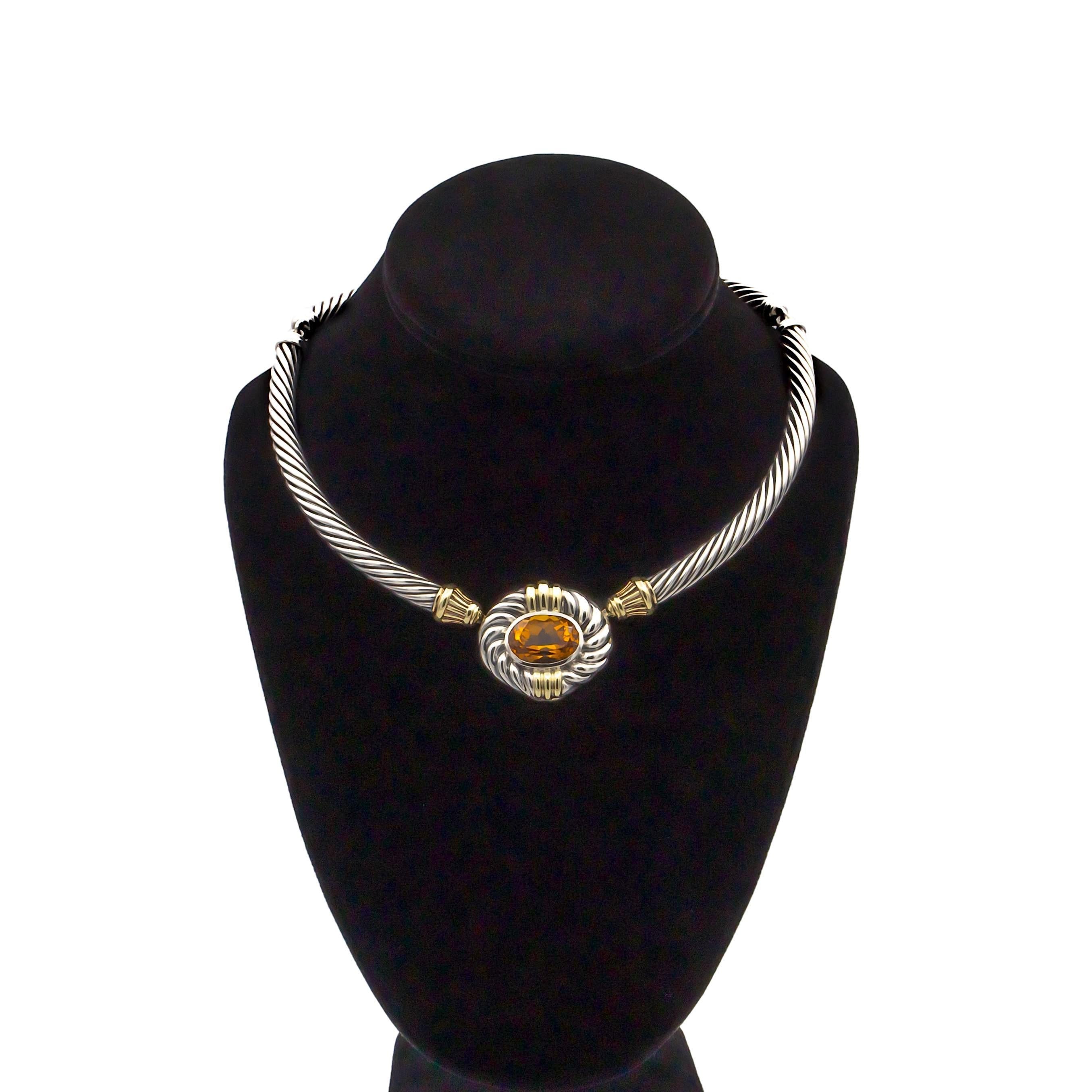 This vintage David Yurman signature cable necklace, from the 1980's or 90's, features a bezel set oval citrine as its centerpiece, measuring approximately 12.5 x 17 mm. The Citrine is in excellent condition displaying a rich, deep orangy hue with