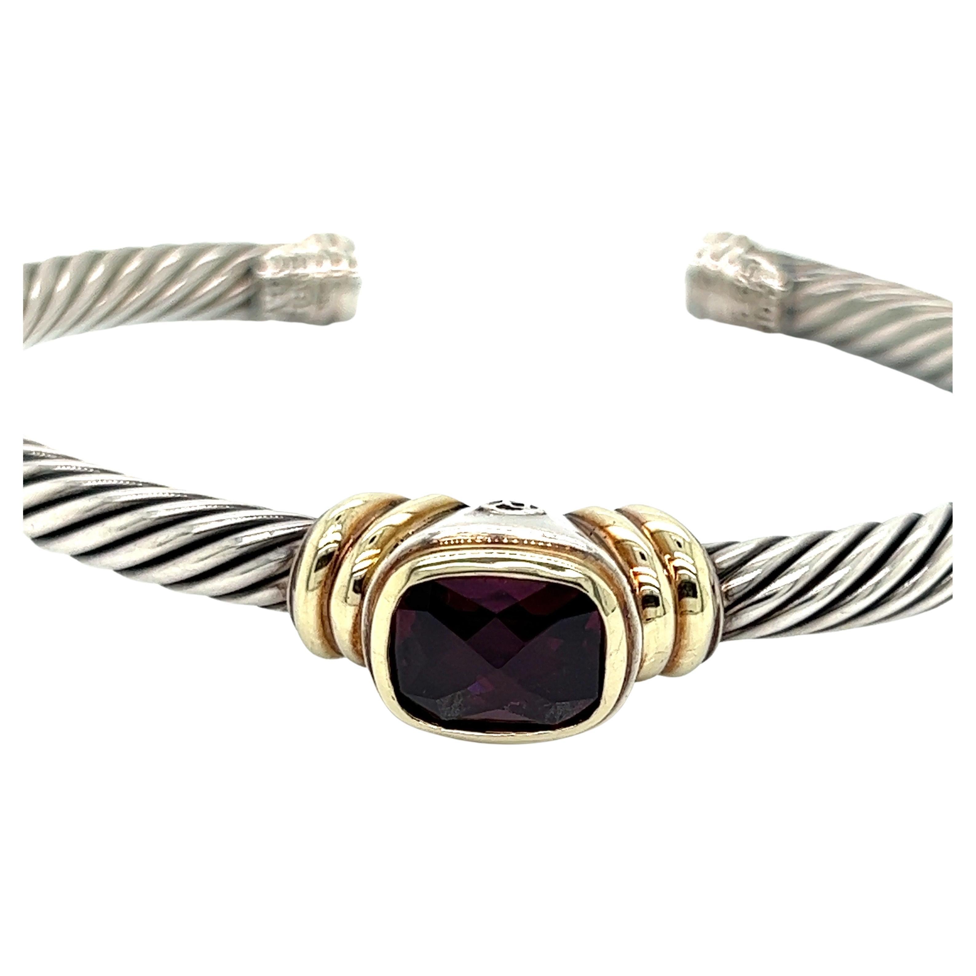 David Yurman's cable bracelet is stunning with the sterling silver perfectly complementing the rhodolite garnet that is cradled in yellow gold. This design has evolved over the years into the classic piece it is today. 

Additional