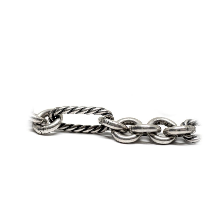 This David Yurman is crafted of sterling silver figaro chain links made in the signature D.Y. cable design. The necklace is accented with an offset 18k yellow gold ring featuring DAVID YURMAN. The extra long chain can be worn as a single long chain