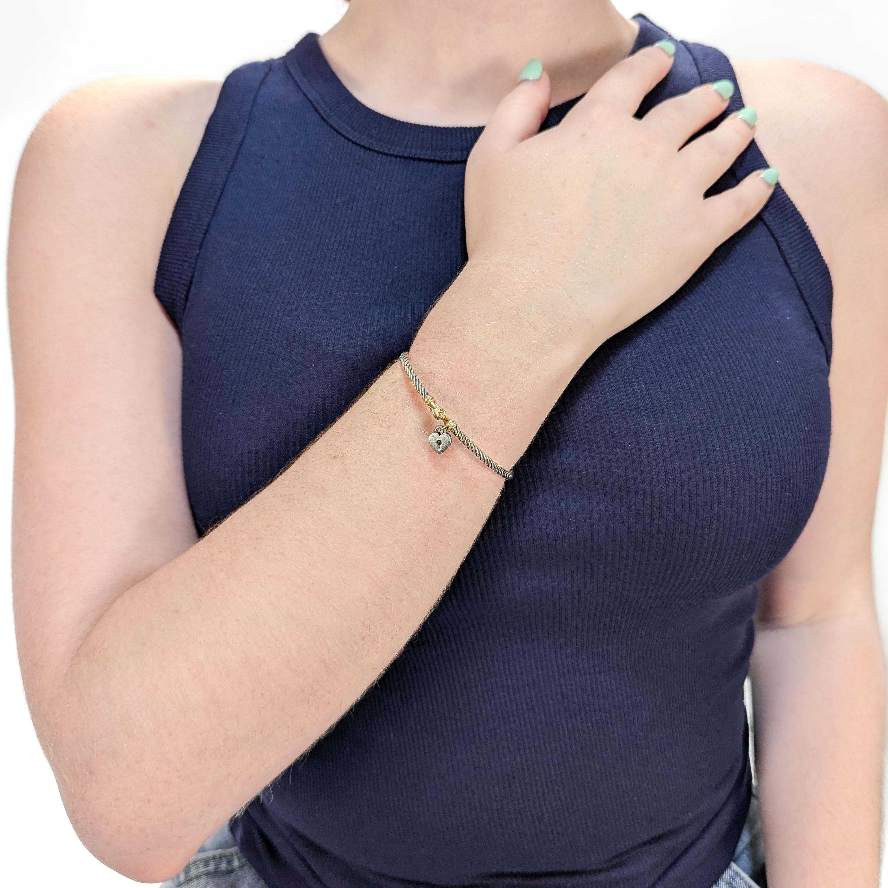 A fine signed silver and gold bracelet.

By David Yurman.

In sterling silver with 14 karat yellow gold accents.

With a silver heart locket attached to the gold terminals.

With a hook and eye closure.

Marked to the hook.

Simply wonderful Yurman