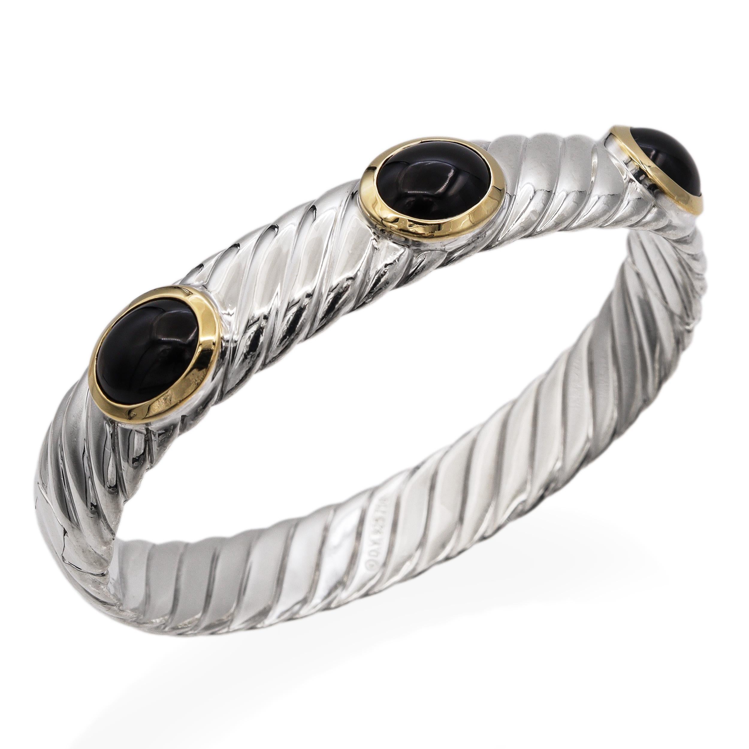 Questo sofisticato braccialetto David Yurman è realizzato in argento sterling con l'iconico design a cavo intrecciato del marchio. Il bracciale è impreziosito da tre cabochon di onice nera liscia, ciascuno incastonato in un caldo oro giallo 18