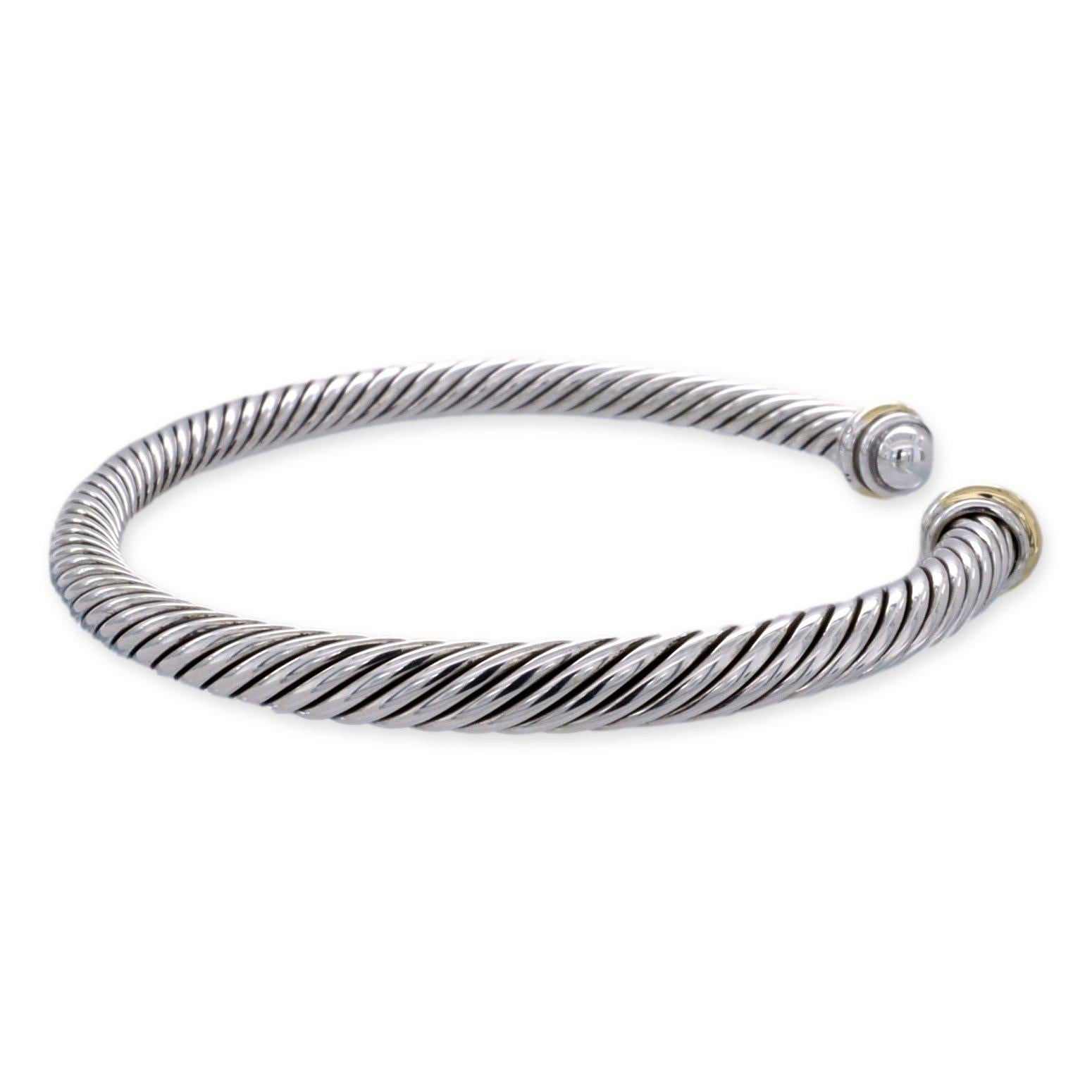 David Yurman open cuff bracelet from the Cable Classics collection finely crafted in sterling silver with two embellishments finished in 18 karat yellow gold. Bracelet measures 4mm and fits wrists up to 6