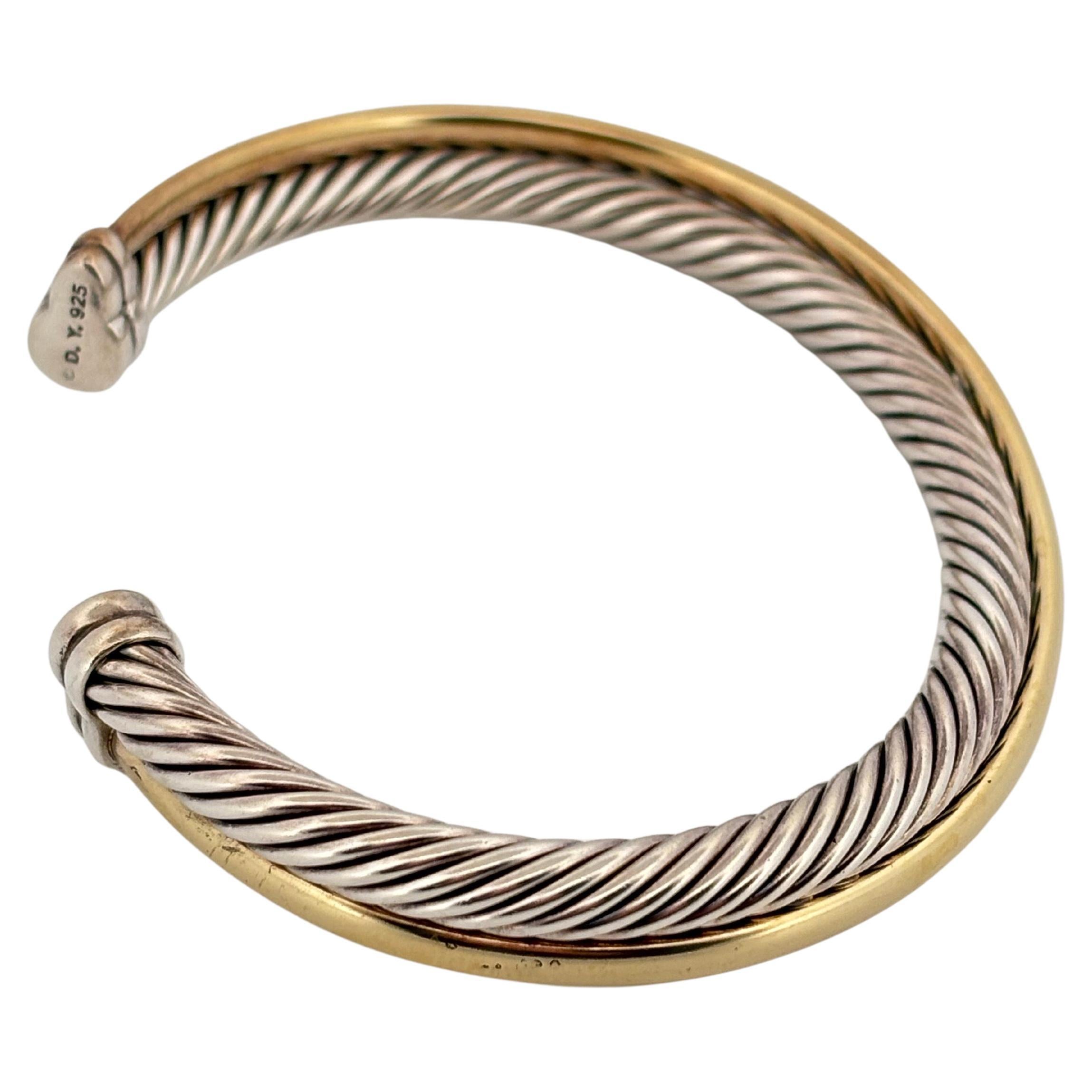 Ce bracelet bangle David Yurman Classic Crossover met en valeur le langage de conception emblématique de la marque, associant un savoir-faire raffiné à une élégance intemporelle. Fabriqué de main de maître en argent sterling .925 et rehaussé d'or