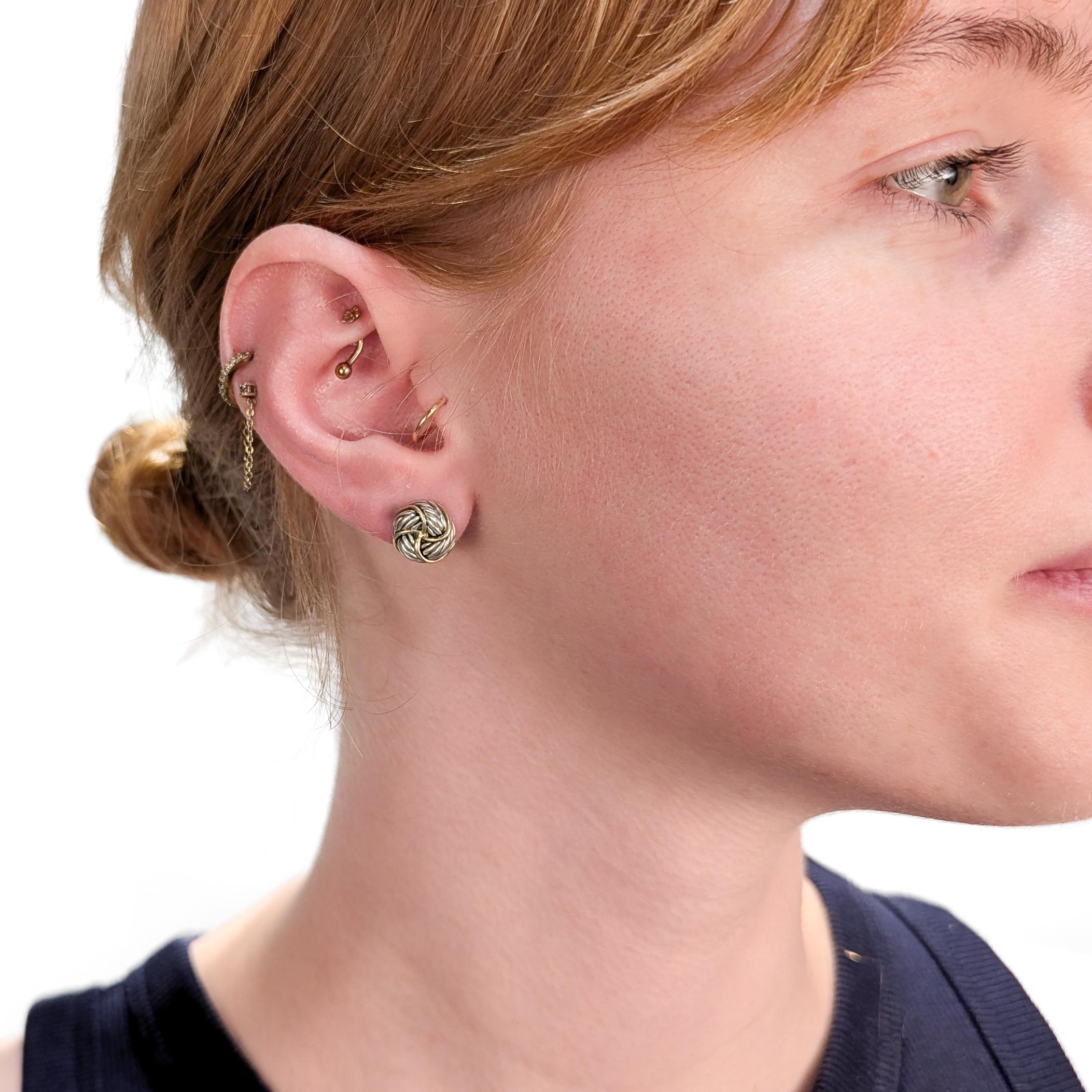 Paire de boucles d'oreilles Infinity Love Knot en argent et or, signées.

Par David Yurman.

En argent sterling avec des accents en or jaune 18 carats.

Avec des fermetures par refoulement.

Marqué au verso de chacun d'eux.

Une paire de boucles