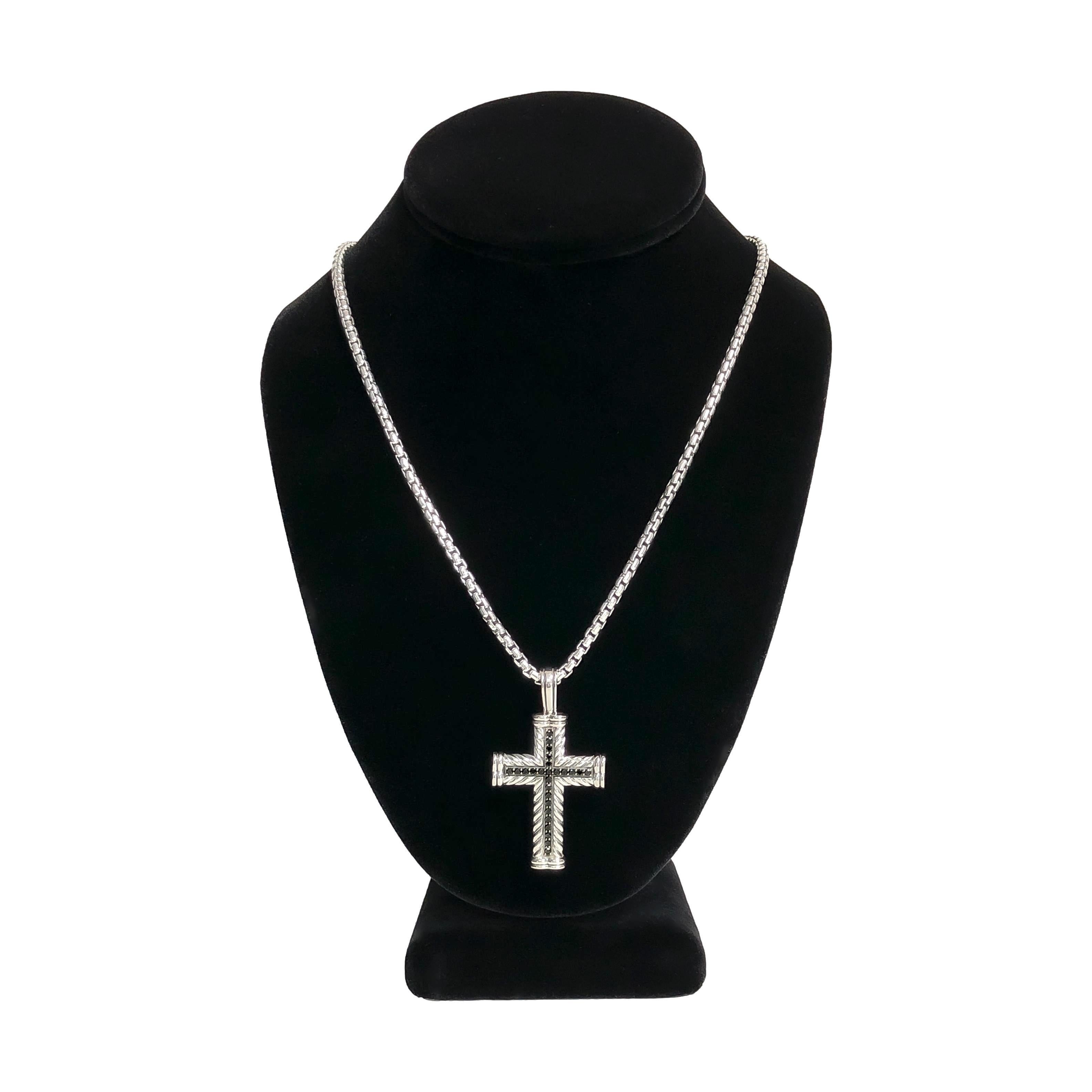 This David Yurman Chevron Cross Pendant necklace is crafted from sterling silver  with a signature cable design and accented with approximately 0.65 carats of black diamonds. The cross measures 2 inches by 1 1/8 inches and is suspended from a