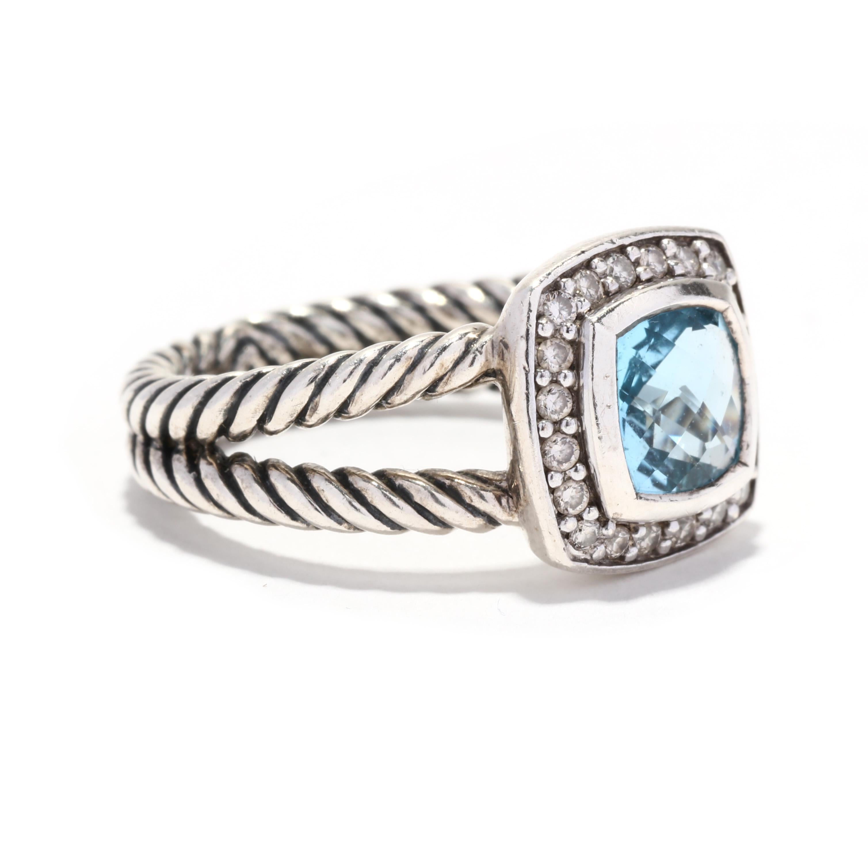 A vintage David Yurman sterling silver blue topaz and diamond albion ring. This November birthstone ring features a bezel set, cushion checkerboard blue topaz weighing approximately 1.83 carats surrounded by a halo of round brilliant cut diamonds