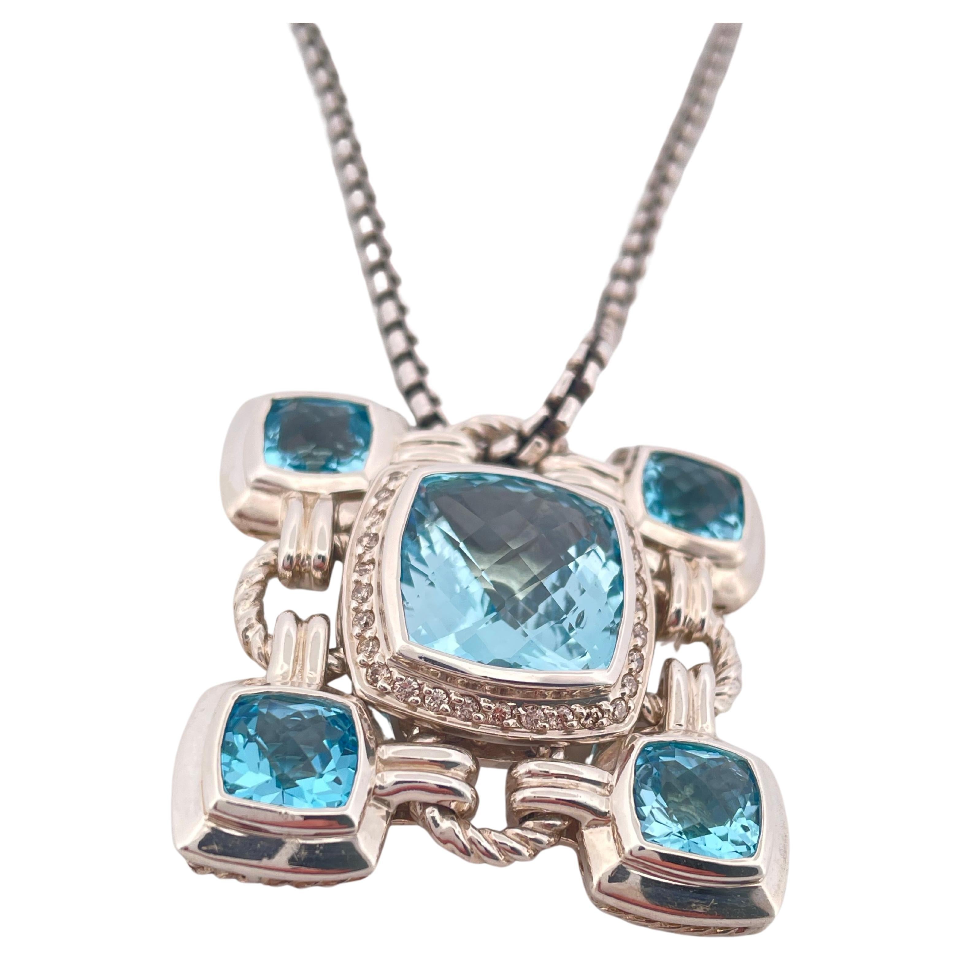 This striking David Yurman Renaissance necklace showcases the designer’s signature artistry in sterling silver with a bold, architectural presence. Weighing a substantial 36 grams, the pendant features a central cushion-cut blue topaz surrounded by