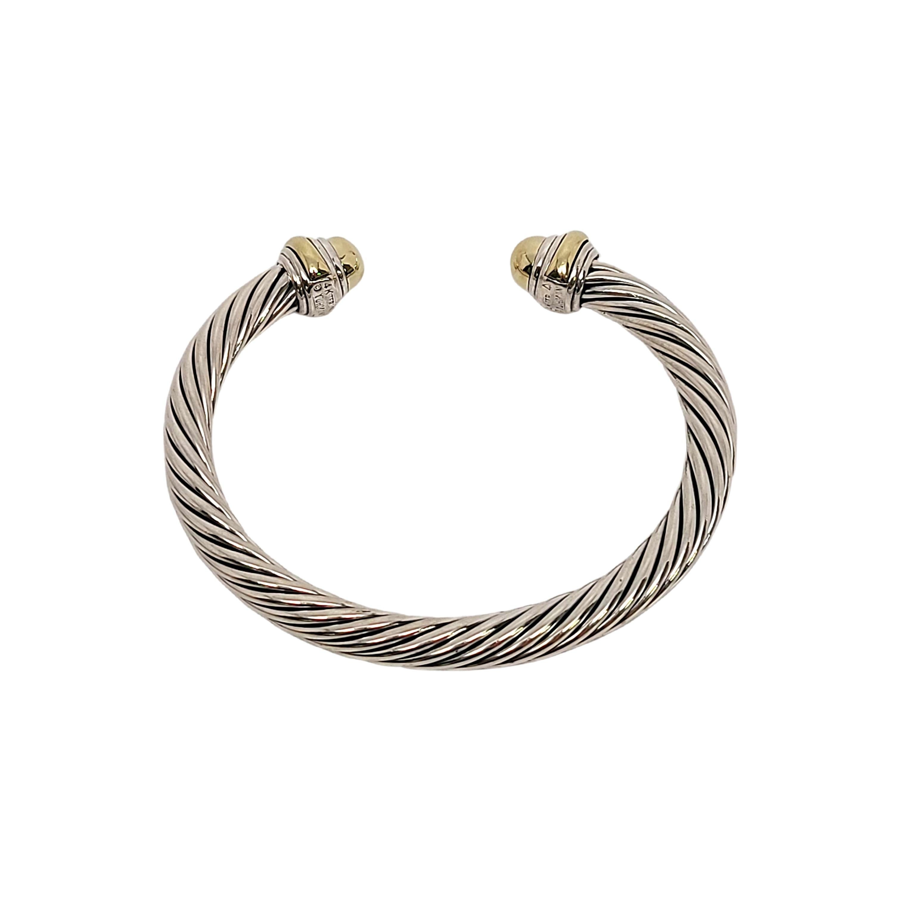 Sterling silver classic cable cuff 14K yellow gold domes cuff bracelet by David Yurman.

Features Yurman's classic cable design in sterling silver with 14K yellow gold accent domes at each end.

Measures approx 6
