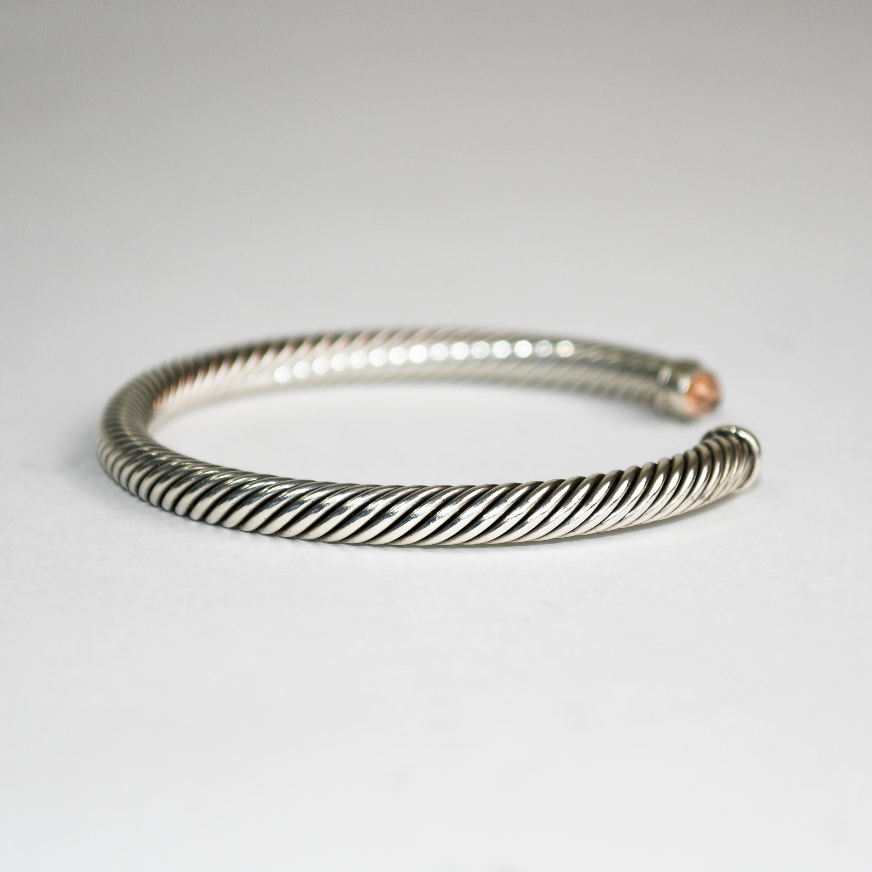 David Yurman classic silver cable bangle bracelet.
Stamped D.Y. 925 and weighs 24.5 grams.
On the ends looks like quartz end stones, but too small to confirm by testing.
The bracelet measures 5mm wide and will easily fit up to 6 inch