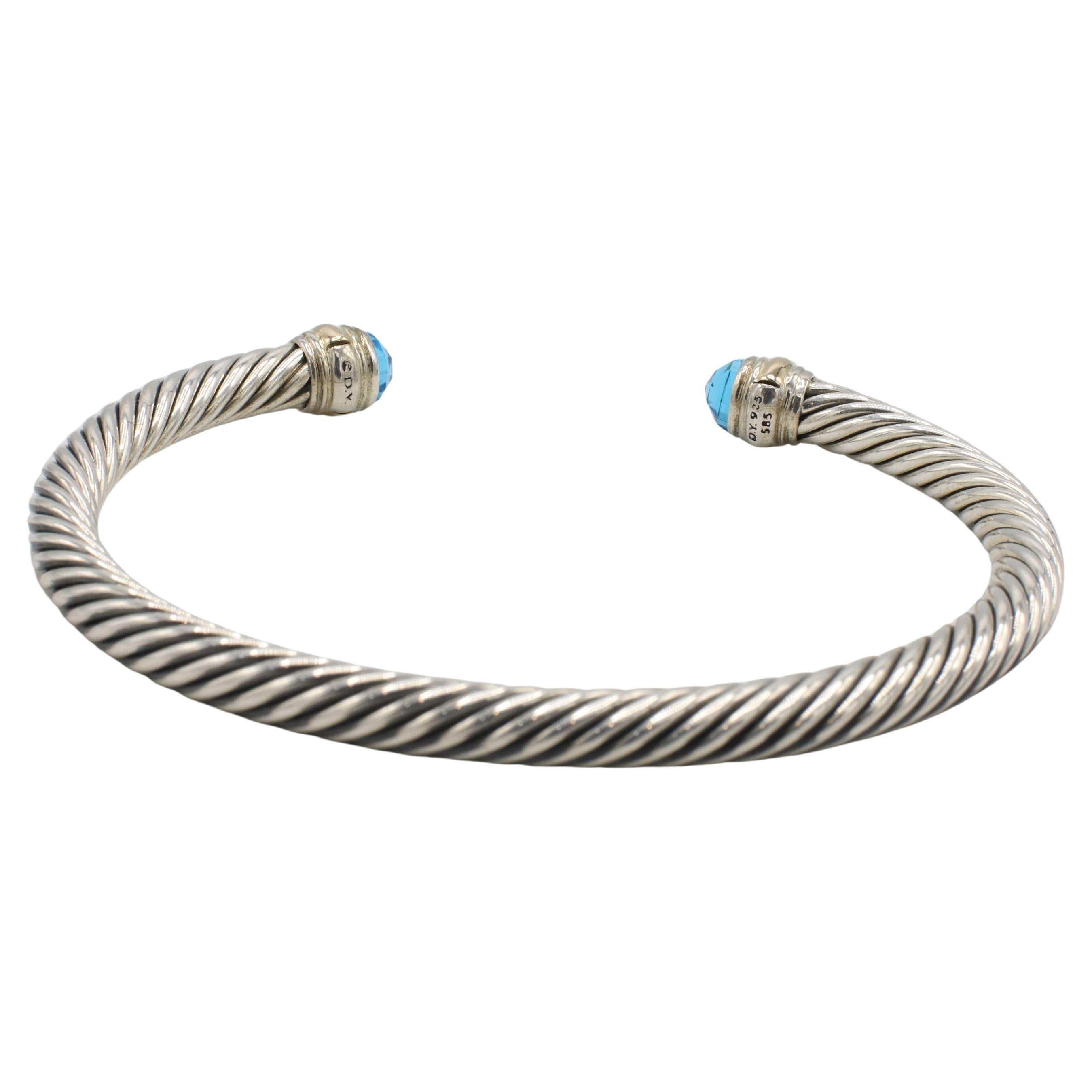 David Yurman Bracciale classico con bracciale a bracciale in argento e oro con cavo di topazio blu
Metallo: Argento sterling e oro giallo 14 carati
Peso: 28,37 grammi
Larghezza: 5 mm
Dimensioni: Si adatta a un polso di 7 pollici.
Pietra preziosa:
