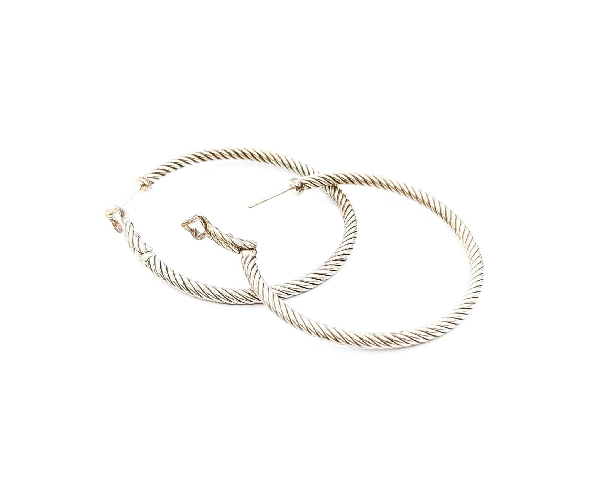 Introducing these exquisite designer fashion earrings crafted in sterling silver by David Yurman. These elegant earrings feature a classic hoop design that embodies timeless sophistication. The sleek sterling silver finish reflects understated