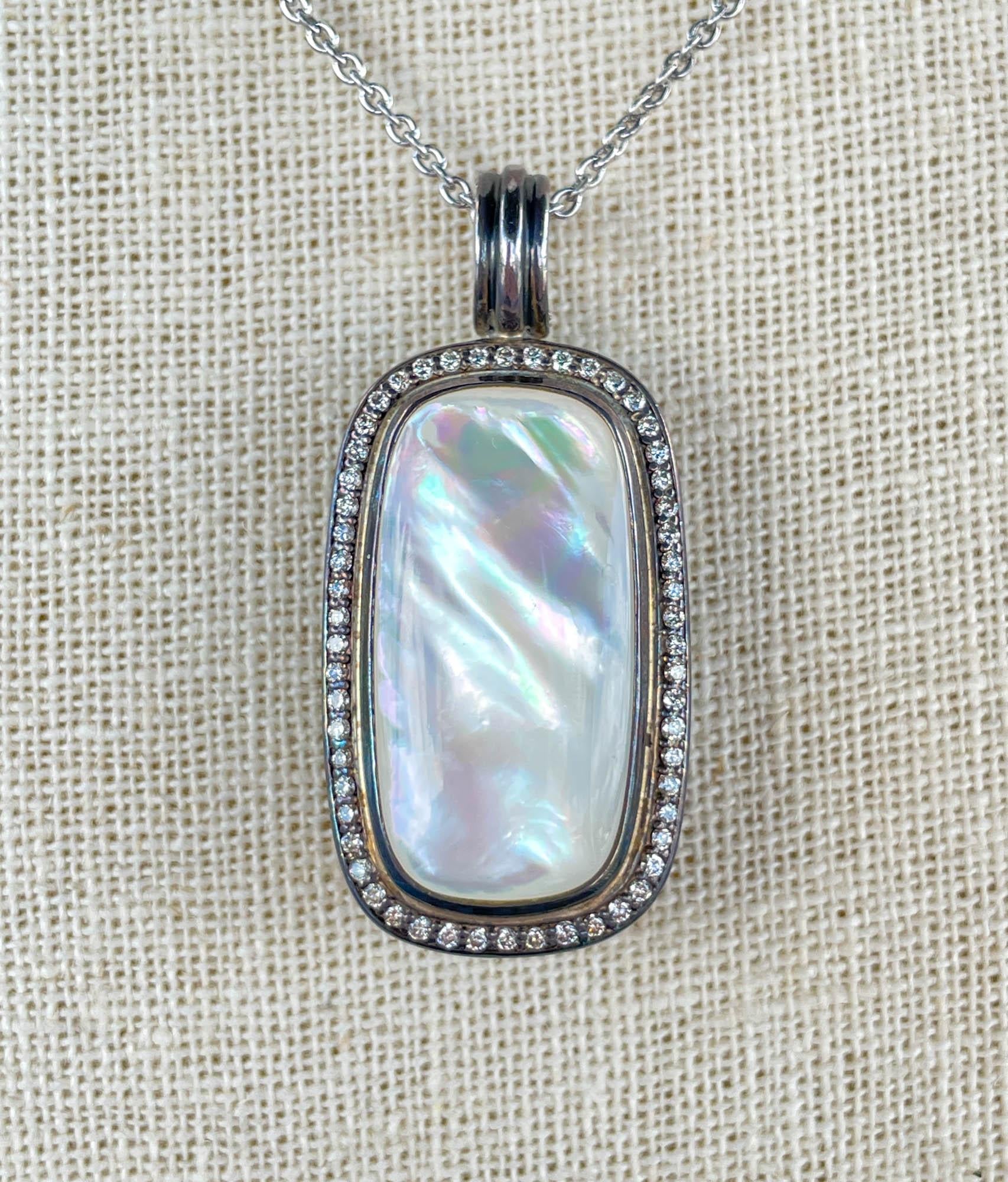 Pendentif en argent sterling nacre et diamant David Yurman.
La nacre mesure environ 30 x 15 mm.
Il y a 56 diamants ronds de taille brillant sertis en halo, dont le poids total est estimé à 0,56ctw.
Les dimensions du pendentif sont de 31x22mm et 42mm