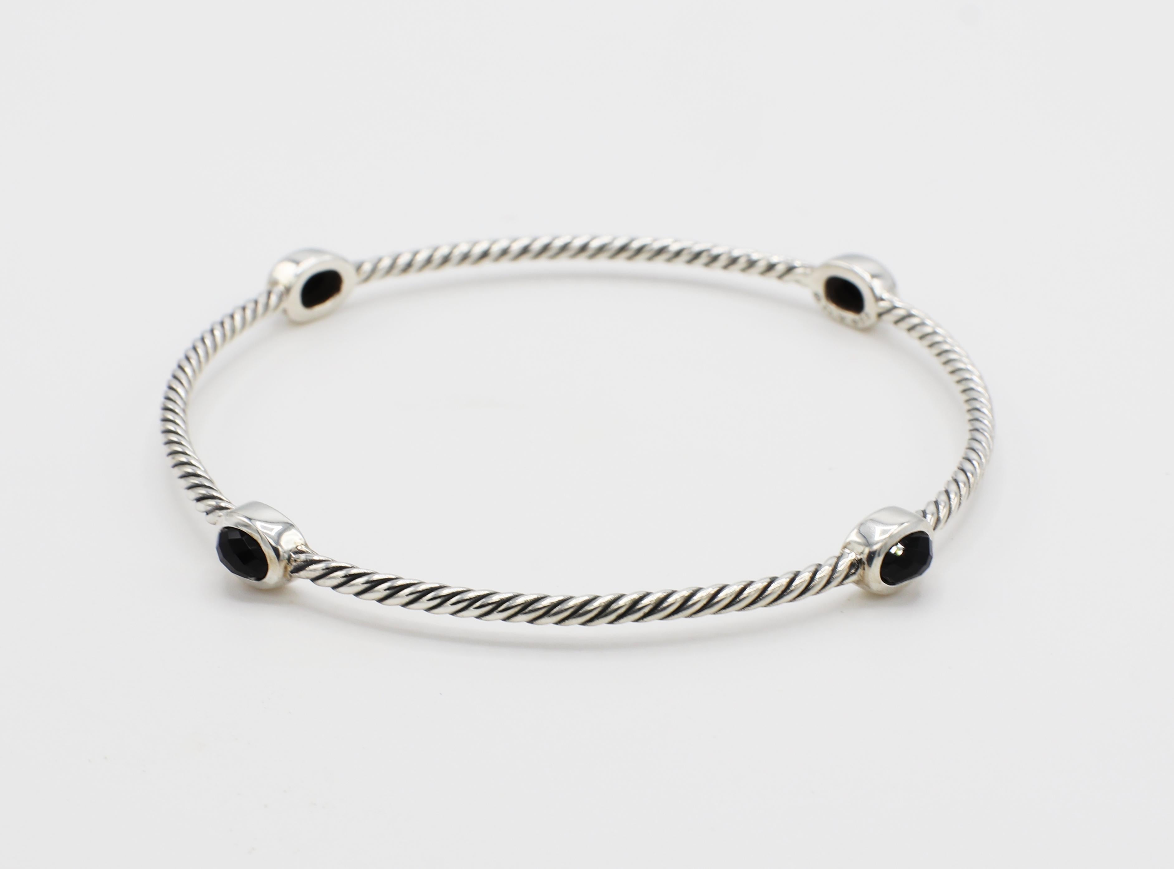 David Yurman Sterling Silber & Onyx 4 Station Kabel-Armreif Armband 
Metall: Sterling Silber
Gewicht: 10.4 Gramm
Onyx: Oval:: facettiert:: je 5::7 x 3::8 mm 
Durchmesser: 68MM
Breite: 2 - 6mm
Unterzeichnet: DY 925