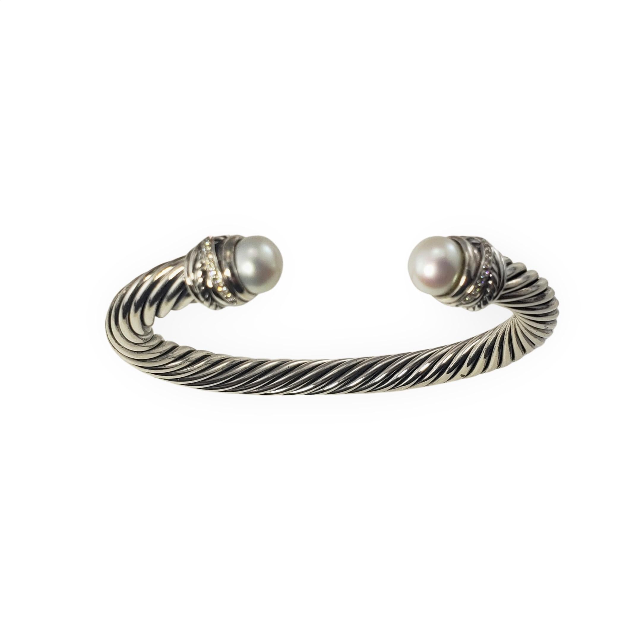David Yurman Sterling Silver Pearl and Diamond Cuff Bracelet-

This lovely cuff bracelet by David Yurman is accented with two white pearls (8 mm each) and 26 round brilliant cut diamonds set in classic sterling silver.  Width:  7 mm.

Approximate