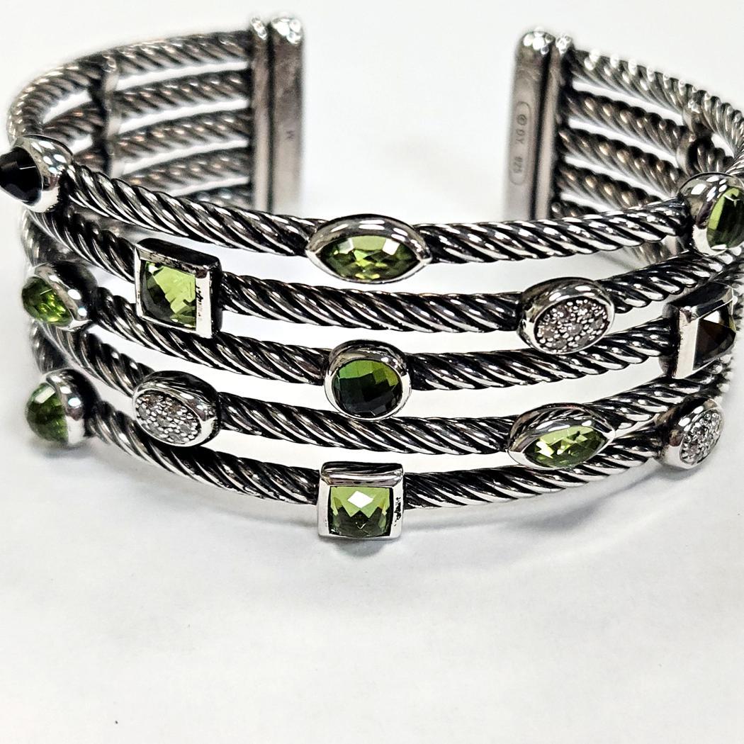 Radiant and sophisticated, this authentic David Yurman Confetti bracelet features five rows of the designer’s iconic twisted sterling-silver cable, enriched with a joyful arrangement of ten luminous faceted peridots in assorted shapes—round, square,