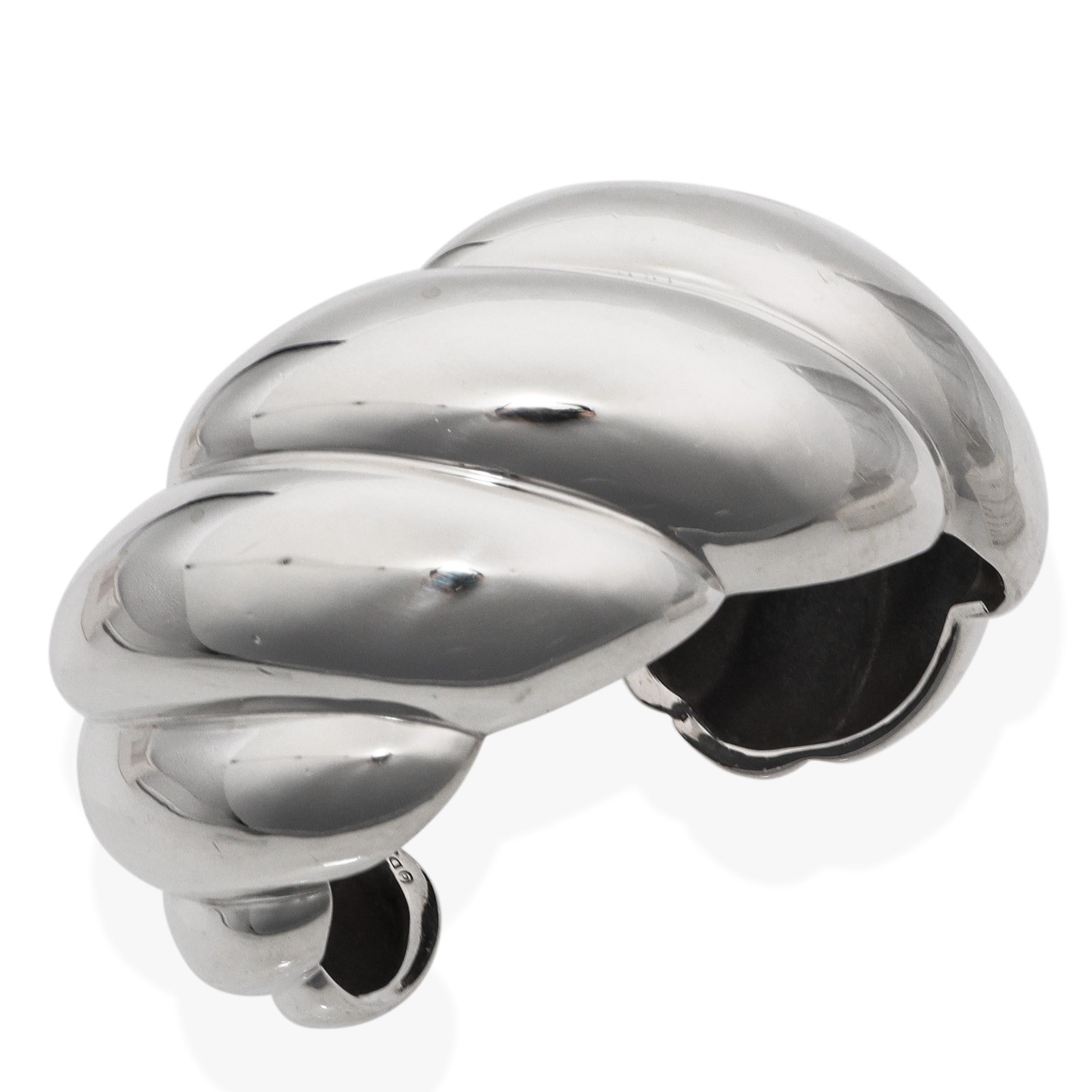 Dieses auffällige Manschettenarmband von David Yurman ist aus massivem Sterlingsilber gefertigt und zeigt das ikonische Sculpted Cable Motiv des Designers in einem kühnen, dimensionalen Design. Die breite, gewölbte Silhouette ist auf Hochglanz