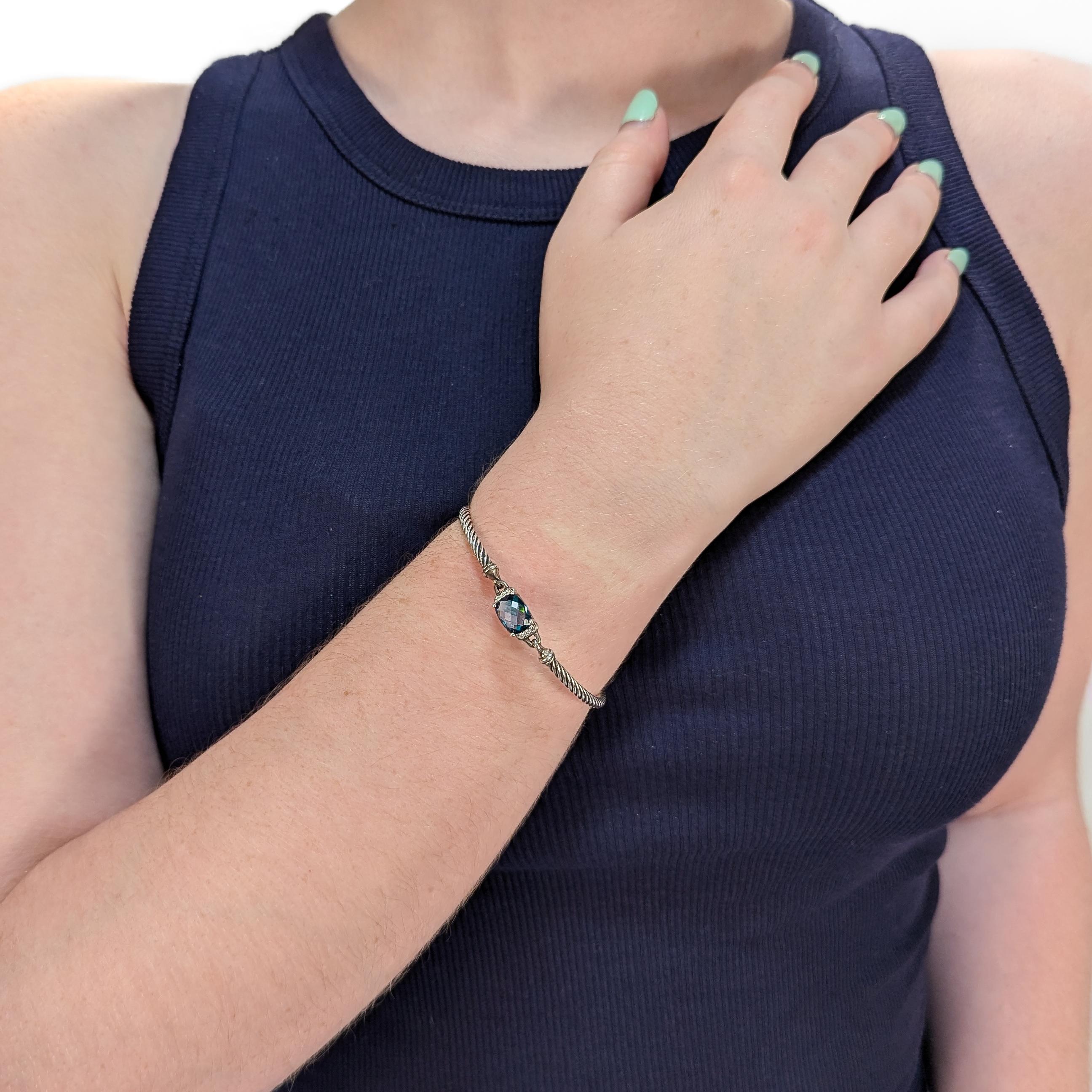 Un raffinato bracciale firmato in argento e pietre preziose.

Di David Yurman.

In argento sterling. 

Nel modello Wheaton.

Con un topazio blu ovale tagliato a cuscino affiancato su entrambi i lati da piccoli diamanti.

Con chiusura a gancio e