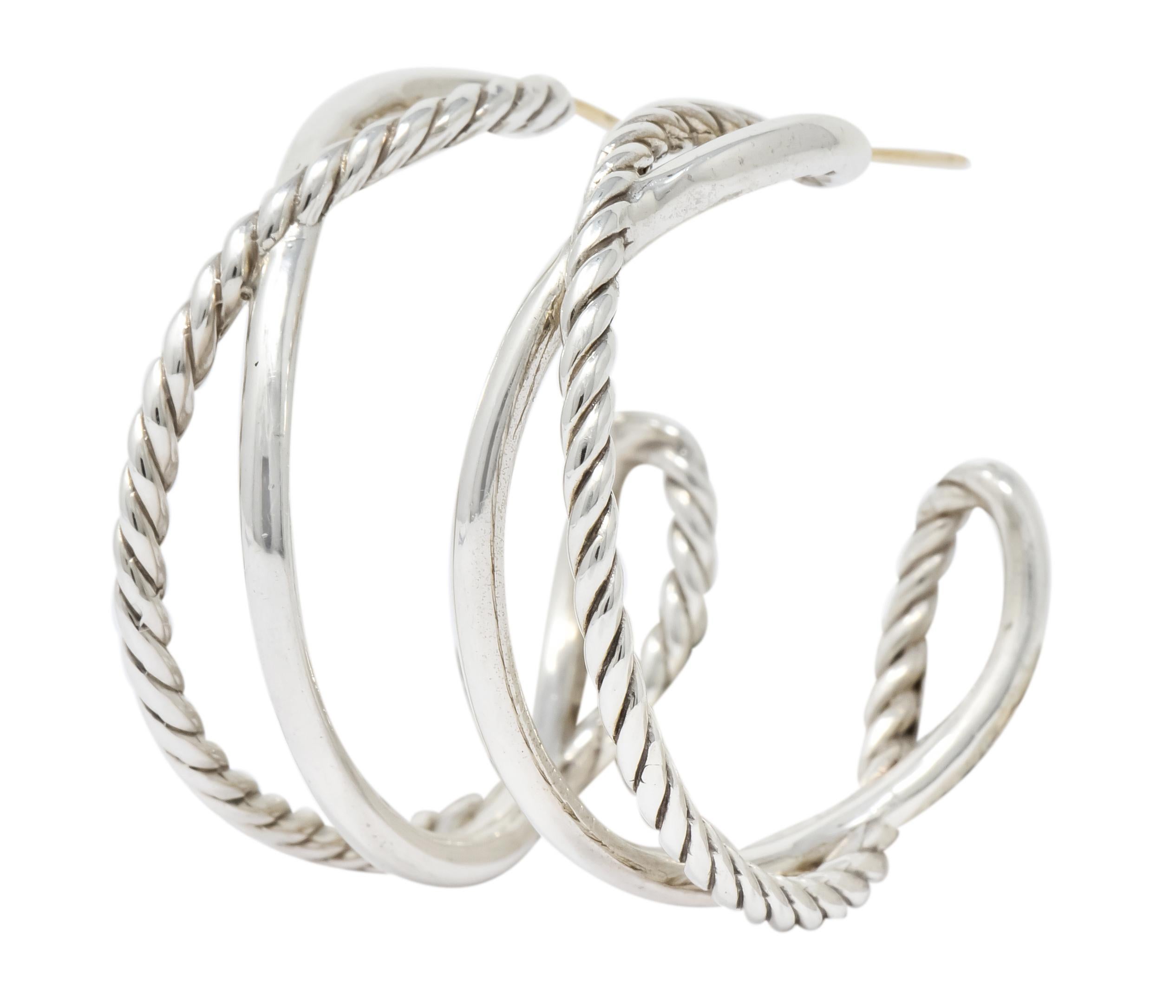 Hoop style earrings comprised of a polished silver section intersecting with a twisted cable section

Completed by posts and friction backs

Stamped DY for David Yurman and stamped 925 for sterling silver

Measuring: 1 3/8 x 5/16 inches

Total