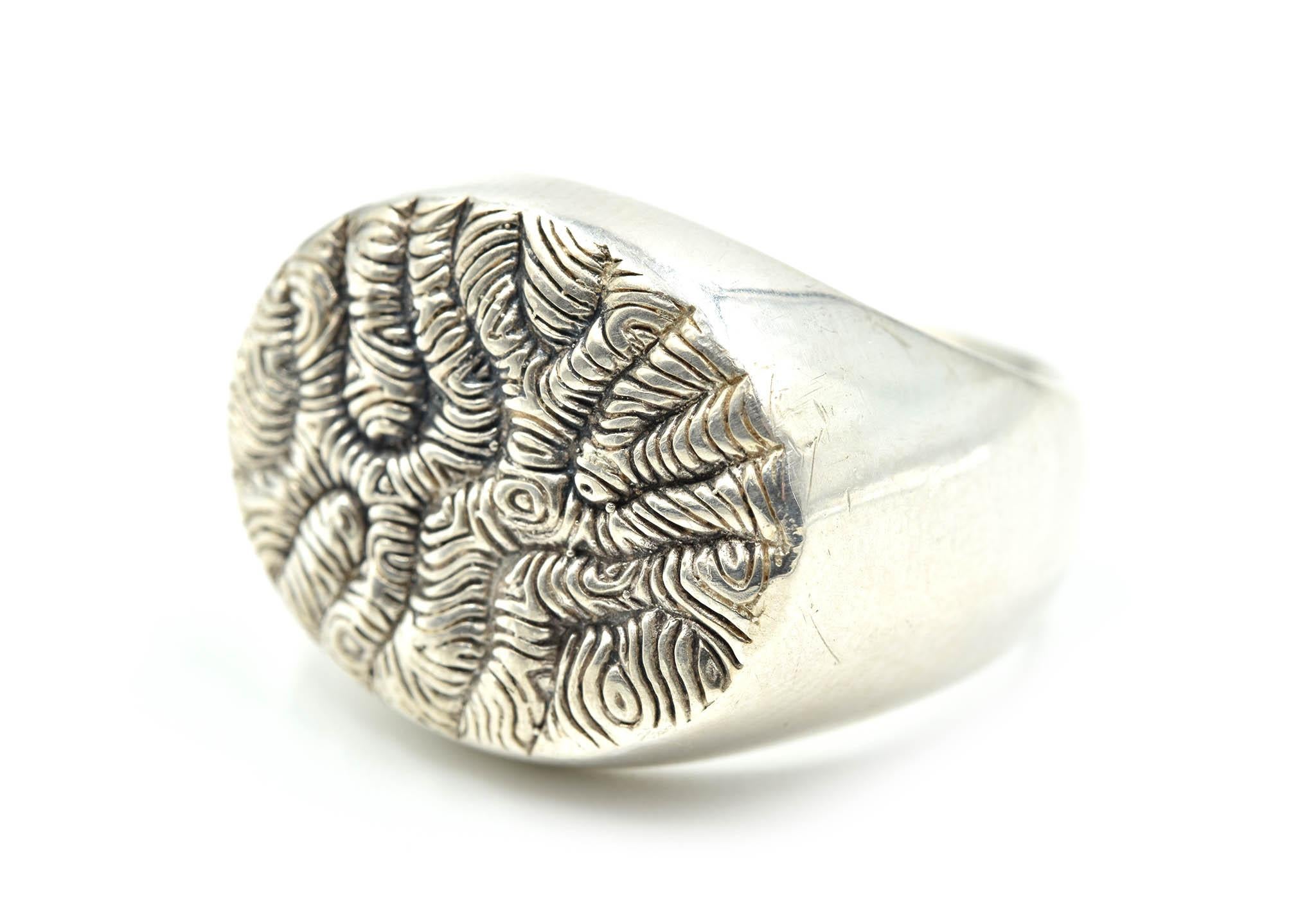 This striking, sterling silver, David Yurman ring features iconic David Yurman designs on the top of the ring. This ring consists of sterling silver with an 18k yellow gold accent! The top of the ring is made with etchings and texture to make the