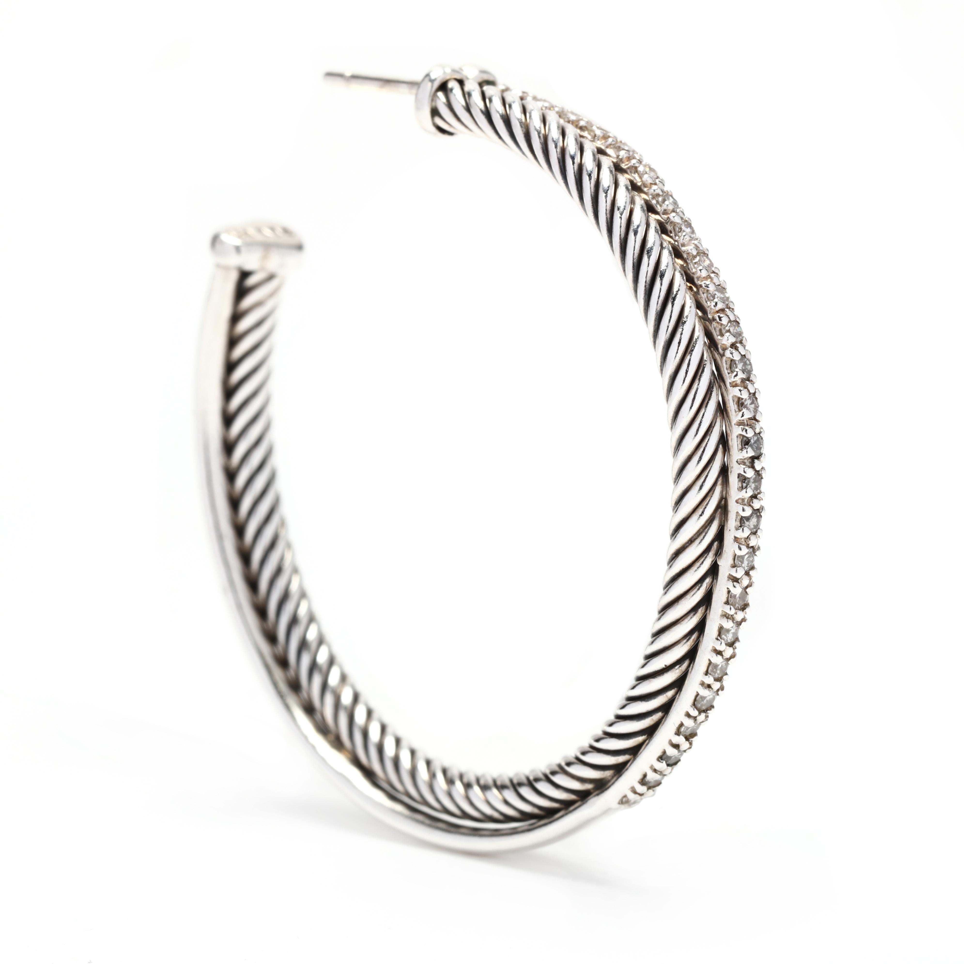 A pair of David Yurman sterling silver diamond x-large crossover hoop earrings. These earrings feature a cable motif hoop with a diamond set crossover weighing approximately .53 total carats and with post and push backs.



Stones:

- diamonds, 50