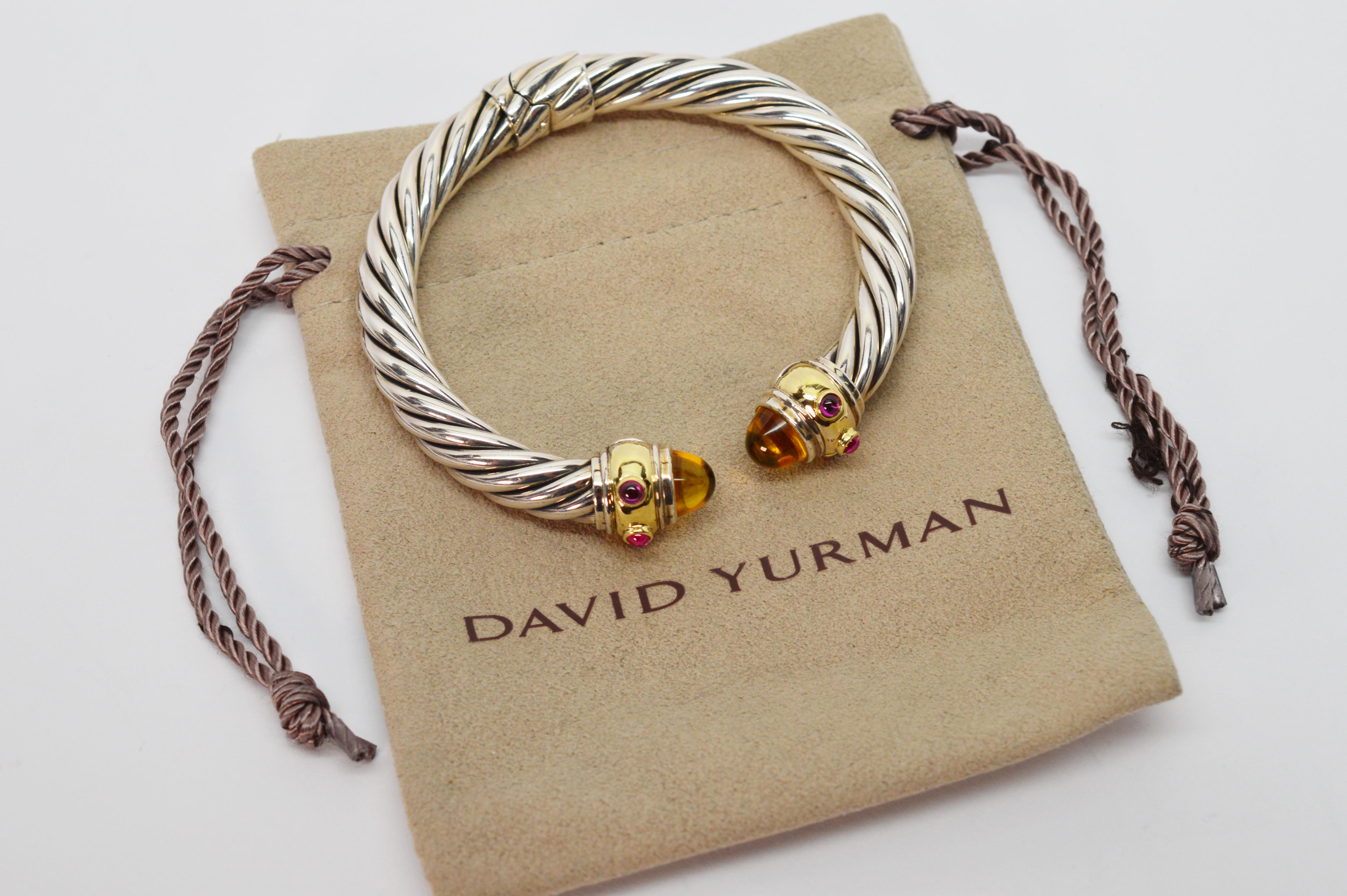 Vibrant citrine pyramid cabochon with ruby cabochon accents enhanced by fourteen karat 14K yellow gold add artful color to this David Yurman Sterling Silver Classic Cable Cuff Bracelet. 
This iconic DY design has an overall measurement of 2-3/4 x