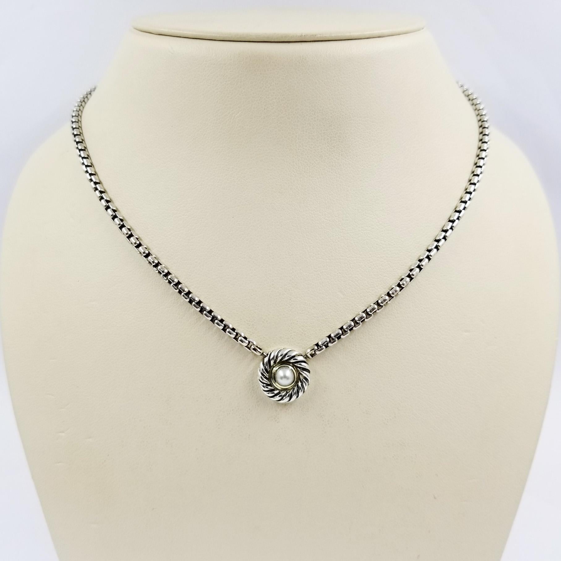 Sterling silver and 14 karat yellow gold necklace from David Yurman. The 16.5 inch rounded box chain features a bezel set cultured pearl. Lobster clasp closure at back of neck. Original MSRP $525.