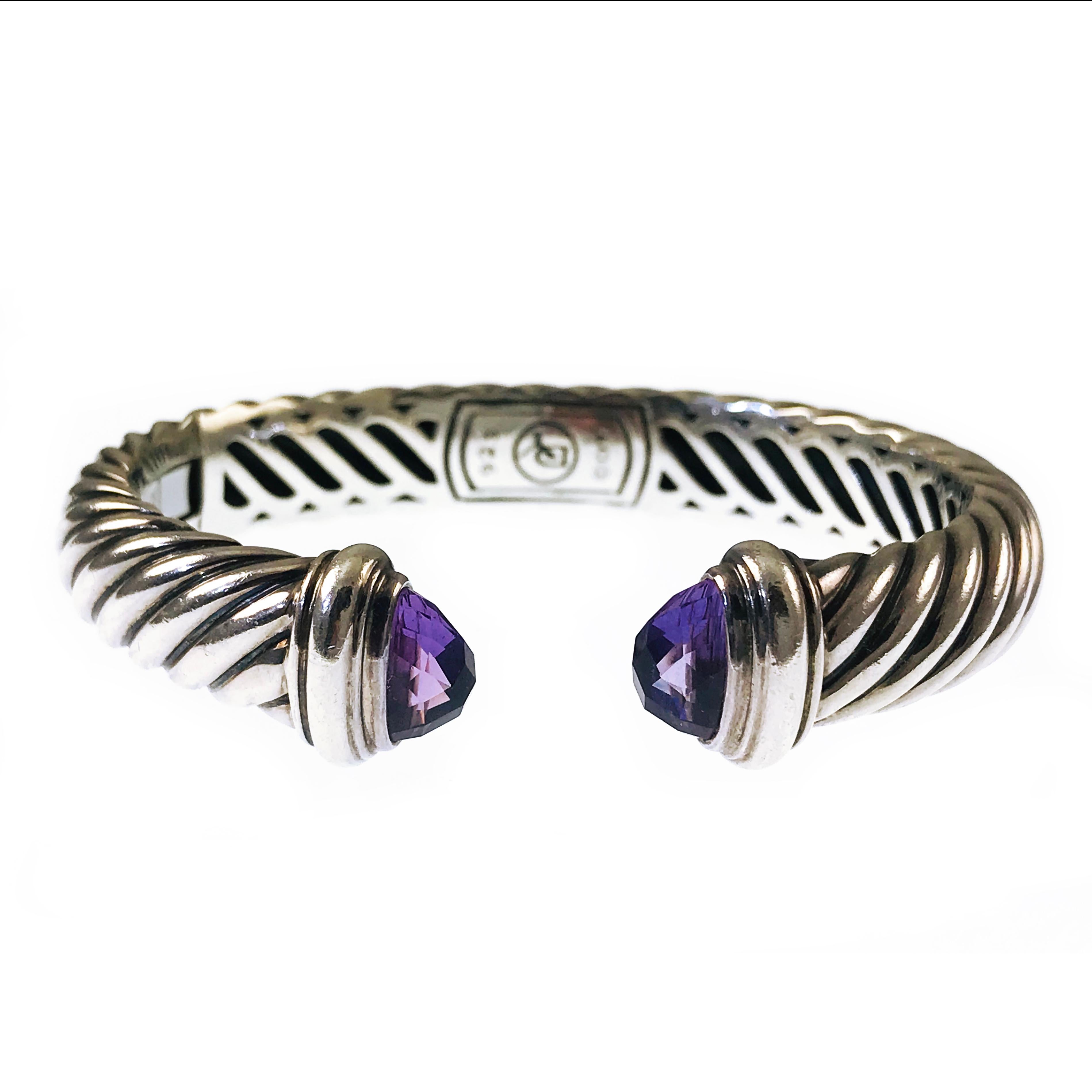 David Yurman Waverly Sterling Silver Amethyst Cable Cuff Bracelet. The classic cable design element creates movement, texture, and depth, the ends contain a faceted Amethyst stone for a sparkly accent. Stamped on the center of the inside of the cuff
