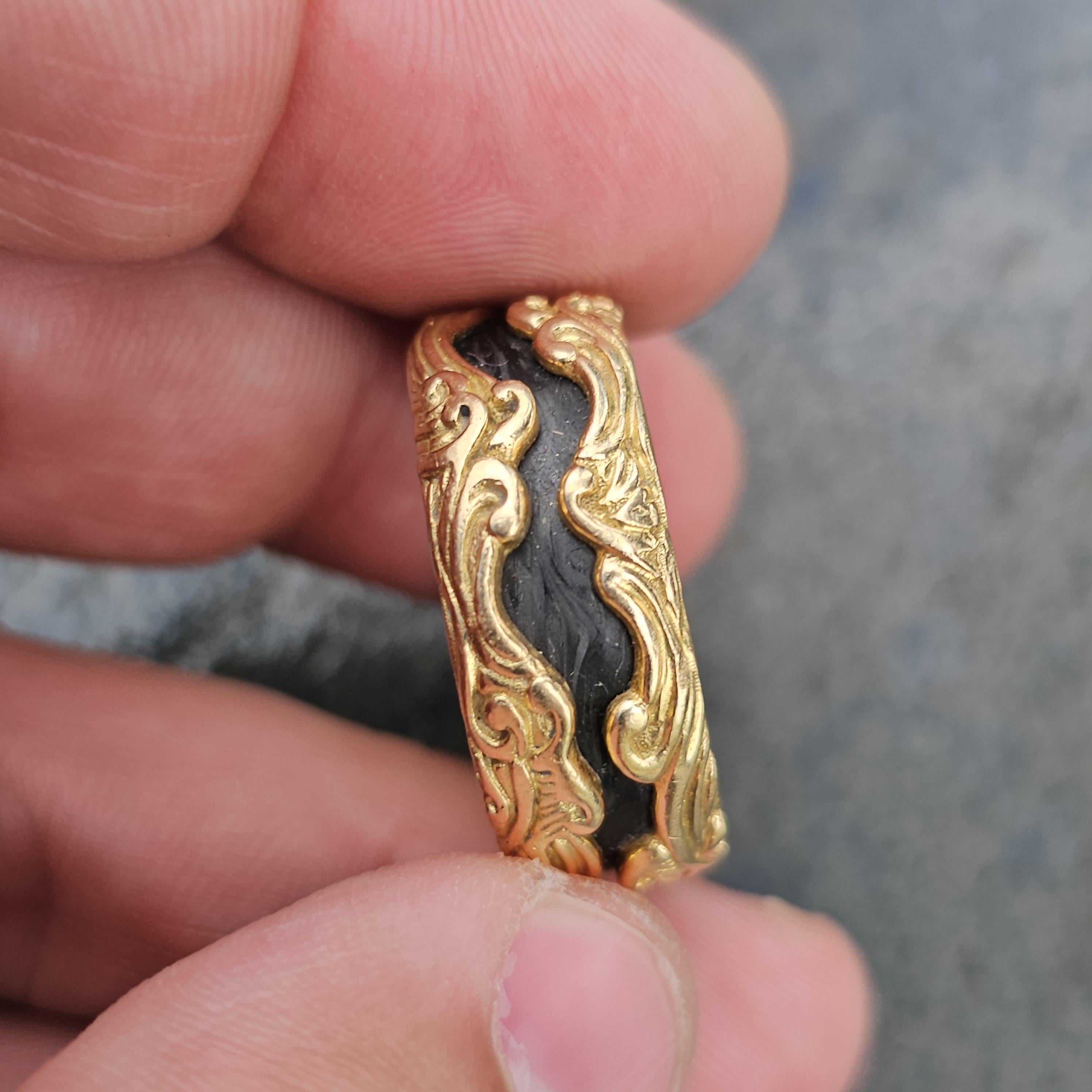 Este llamativo anillo de David Yurman está fabricado en lujoso oro de 18 quilates y carbono forjado. El intrincado diseño presenta elegantes motivos fluidos que envuelven una banda oscura de carbono forjado texturizado, creando un cautivador