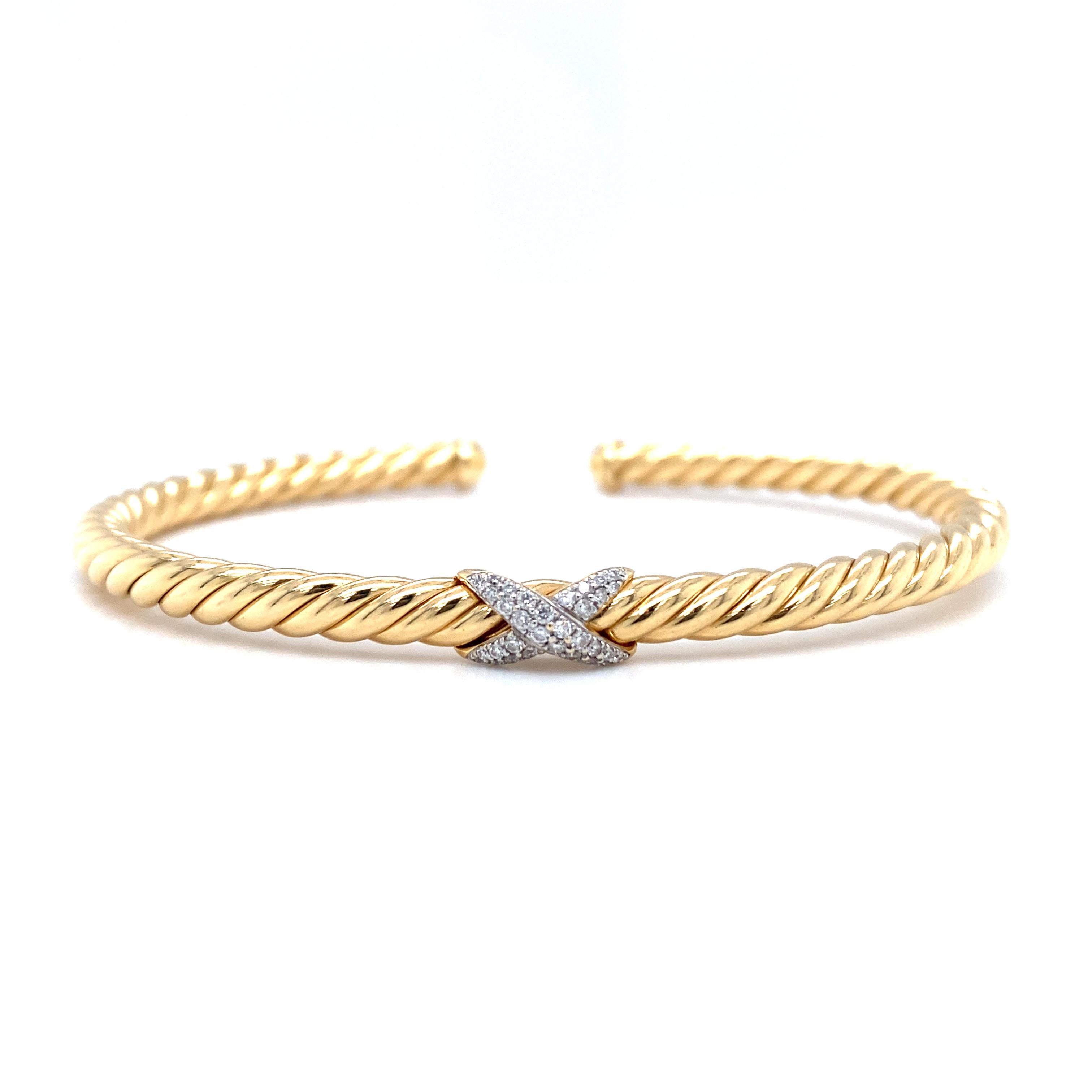 Item Details: This cuff bracelet by David Yurman features a trademark X design popularized by the designer, with a beautifully crafted twist motif. The bracelet is expertly made in 18 karat yellow gold, and features brilliant round diamonds.

This