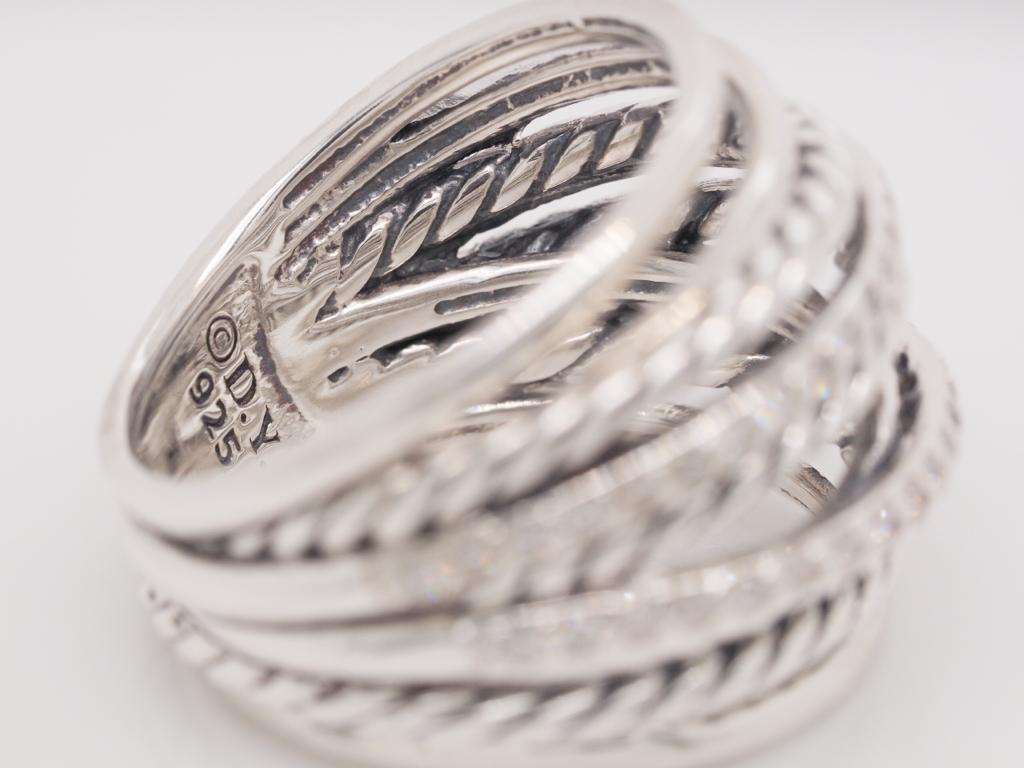 This David Yurman Crossover ring features approximately 0.67 carats of pave diamonds in the design. The material is Sterling Silver. The stamps 