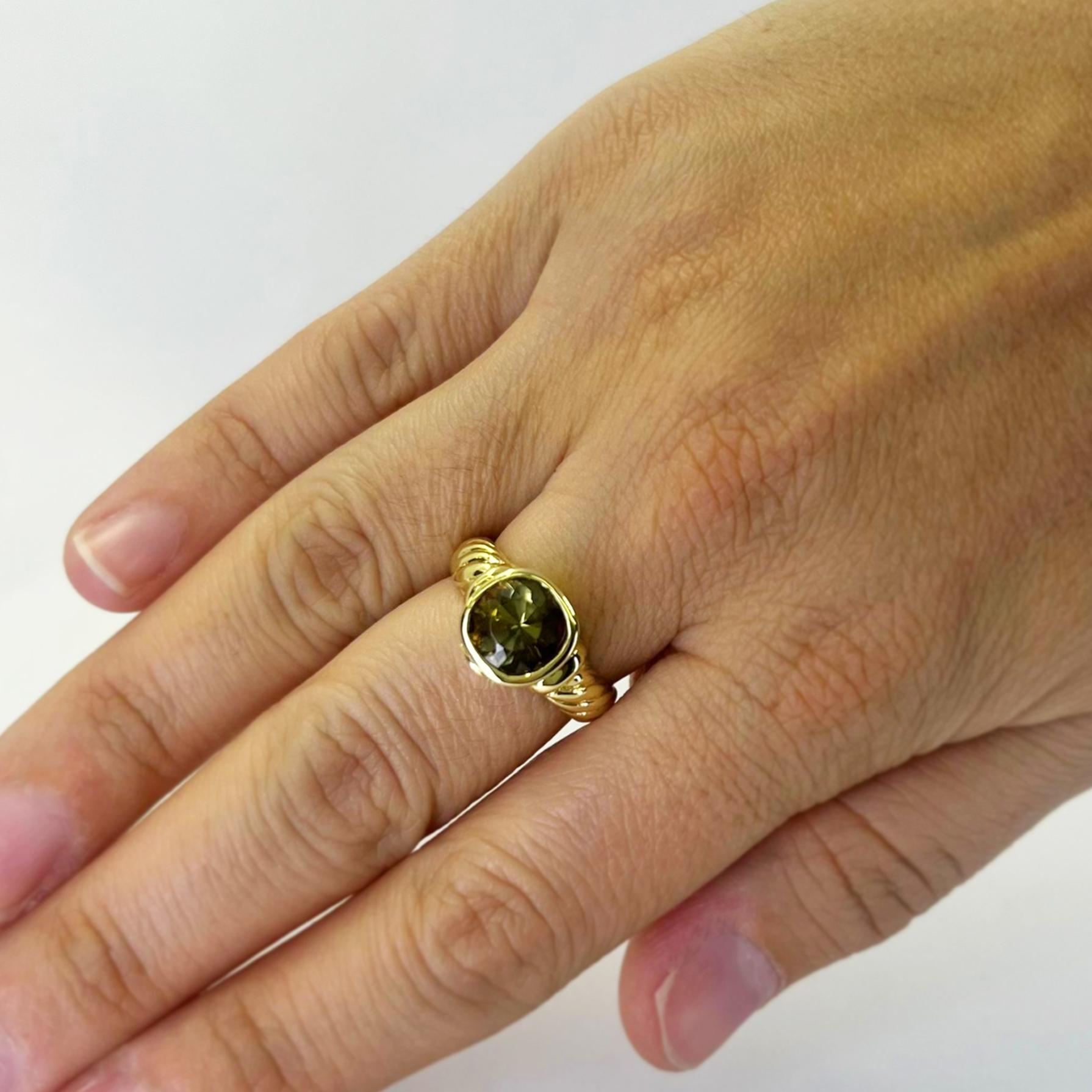 David Yurman 18 karat yellow gold cable ring featuring a cushion shaped bezel-set green tourmaline. Finger size 7.25. Includes One Sizing Service Upon Request, Prior to Shipping and David Yurman travel pouch. Finished weight is 9.7 grams. $2,000+