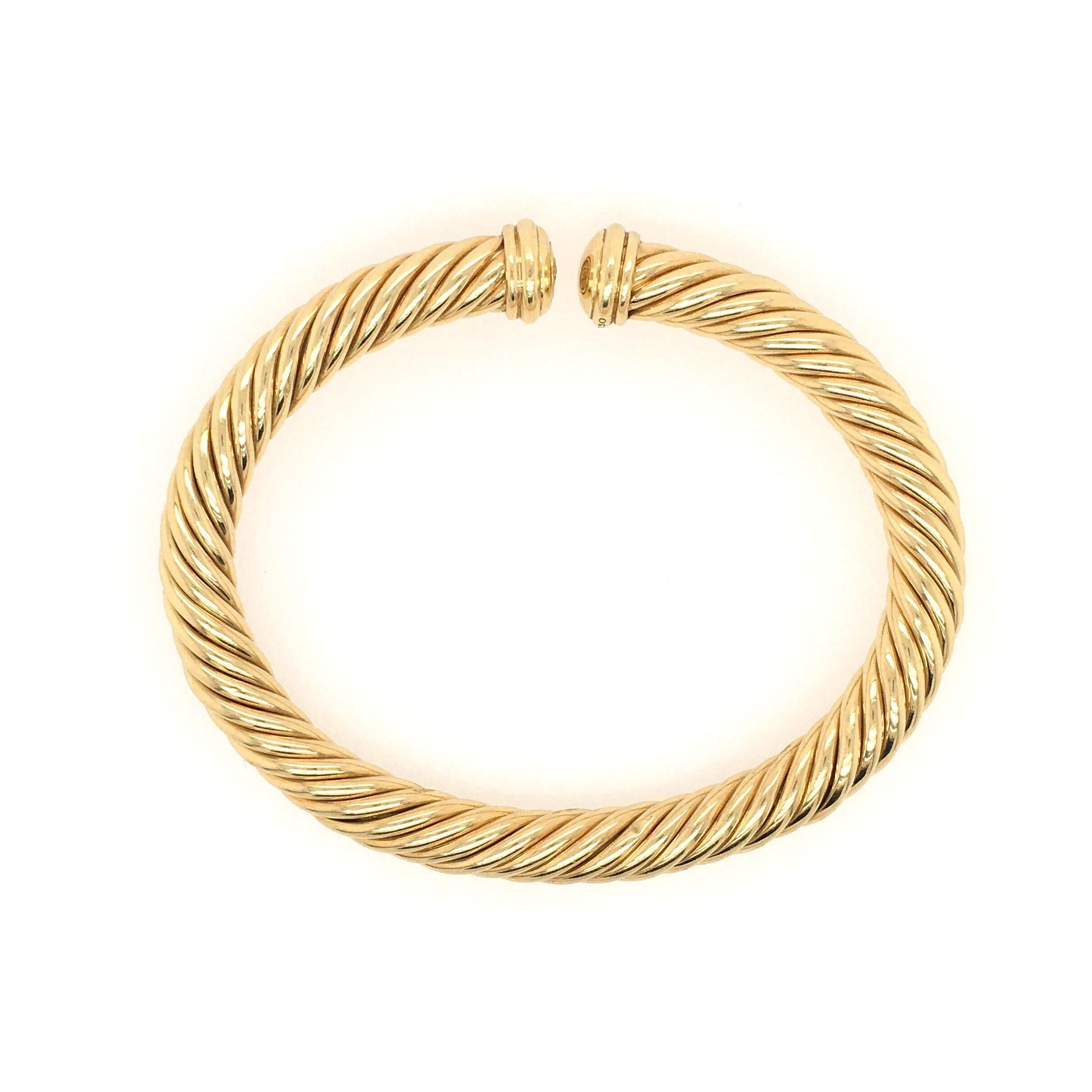 An 18 karat yellow gold Cable Spira Bracelet. David Yurman. Designed as a slightly flexible polished gold open bangle, terminating in fluted domes. Width is approximately 6.5mm., inside measurement is approximately 6 1/4 inches, gross weight is