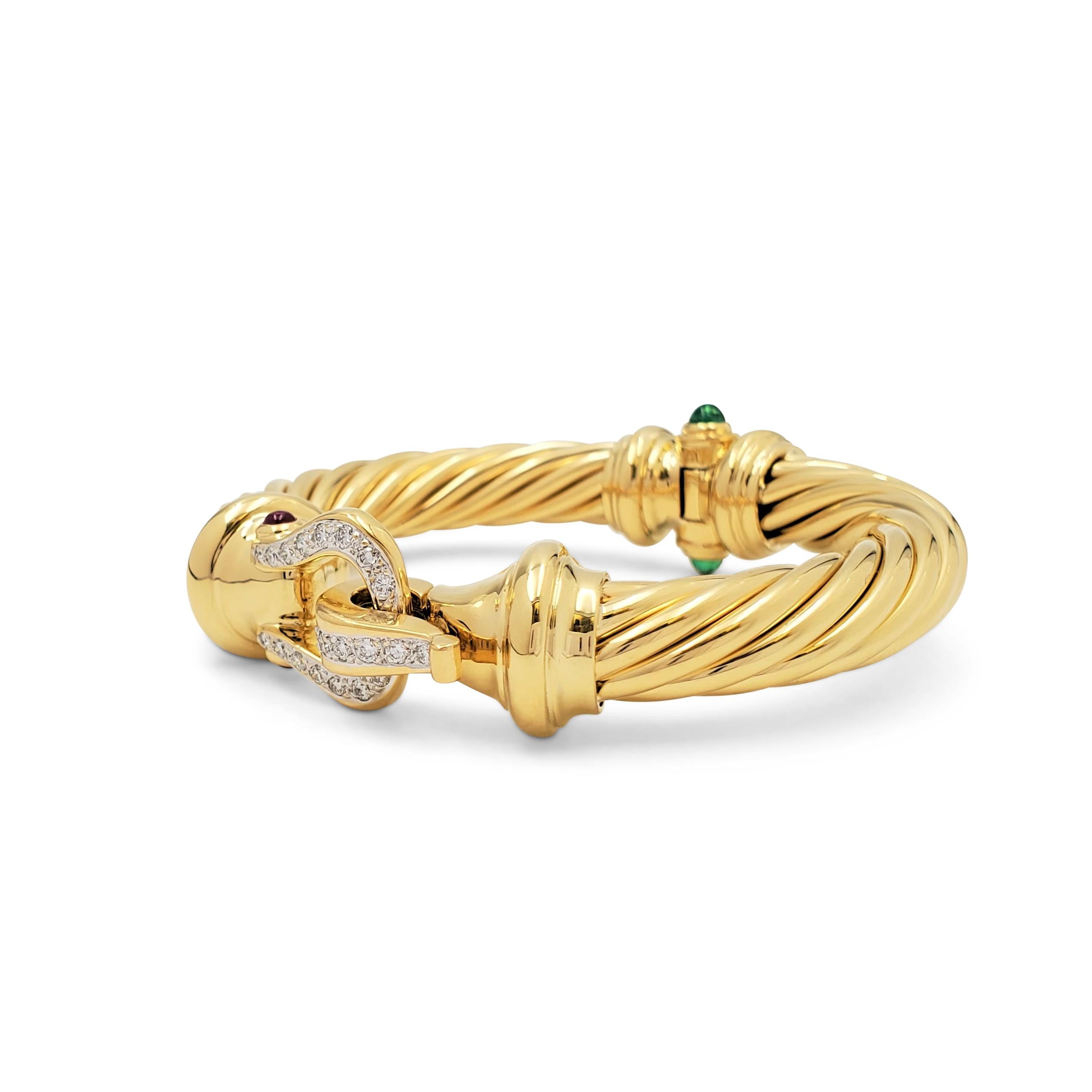 Authentic David Yurman Cable bracelet crafted in 18 karat yellow gold features a buckle motif that is set with an estimated 0.35 carats of round brilliant cut diamonds (E-F, VS). Cabochon cut emerald and ruby stones accent the piece. Signed D.Y.,