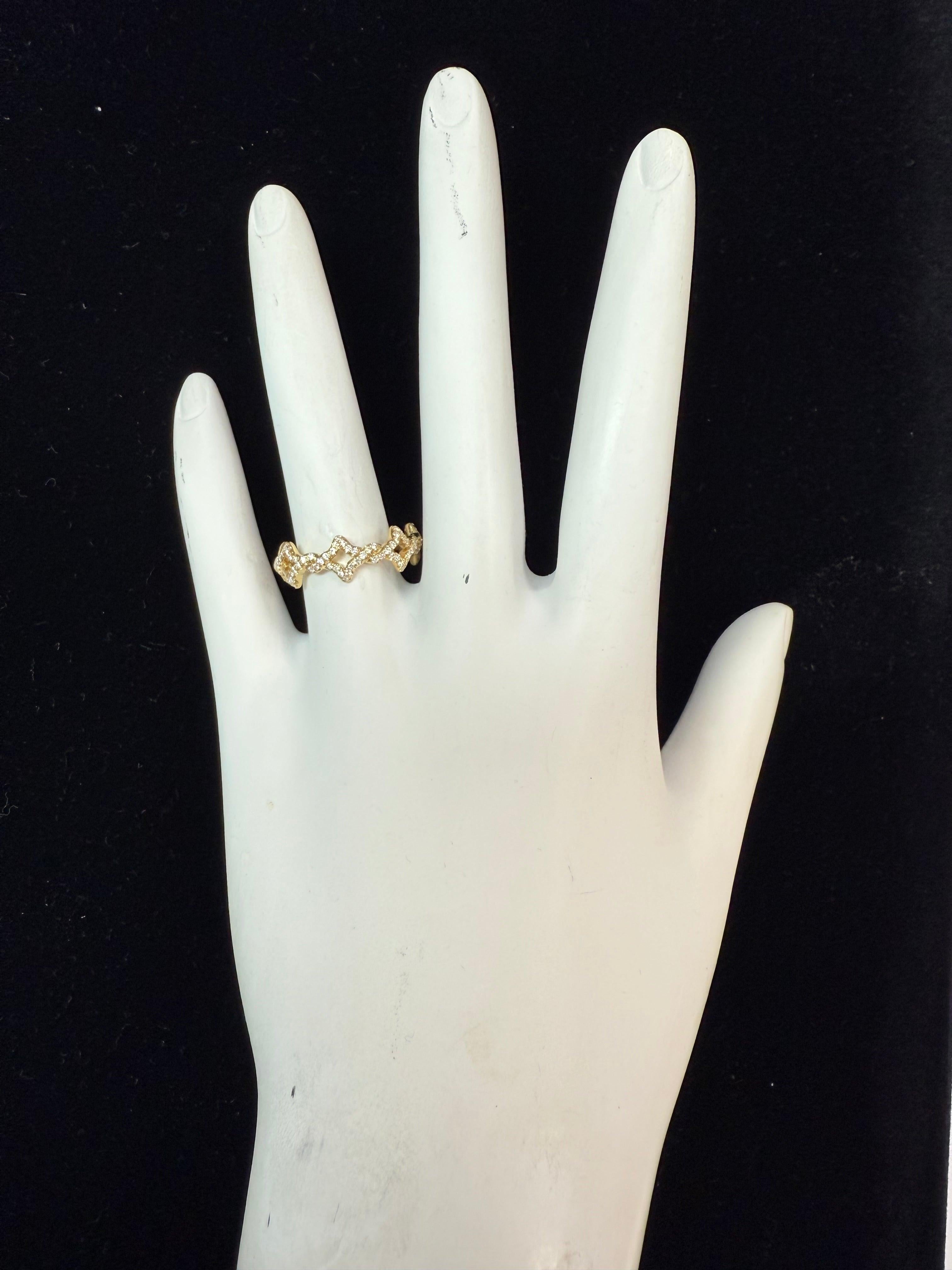 Questa fascia per l'eternità, appartenente all'elegante collezione Venetian Quatrefoil di David Yurman, è finemente realizzata in oro giallo 18 carati e impreziosita da circa 0,50 carati di diamanti naturali. I caratteristici motivi a quadrifoglio