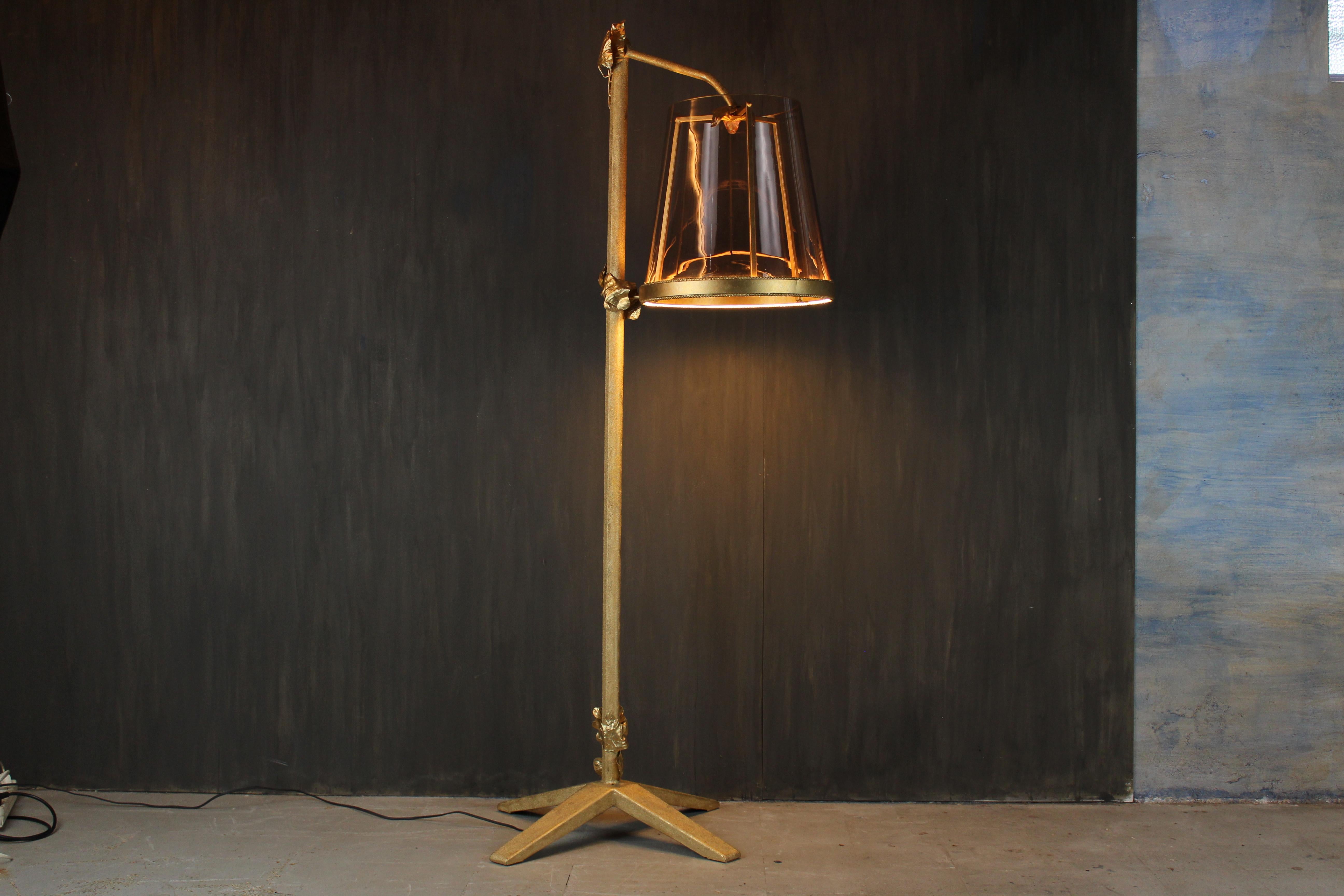 A unique sculptural floor lamp by Italian artist Davide Moretto, handcrafted with a cast iron base lacquered using gold powder and adorned with hand-forged golden leaves. The shade is composed of a rare 1950s Murano glass vessel in amethyst tones,