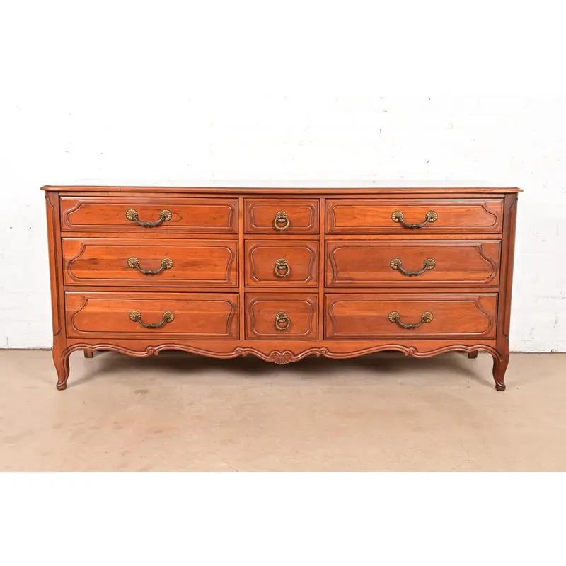 Exceptionnelle longue commode ou crédence de style Louis XV français provincial

Par Davis Cabinet Co.

USA, Circa 1960

Bois massif de cerisier sculpté, avec quincaillerie en laiton d'origine.

Dimensions : 71,5 