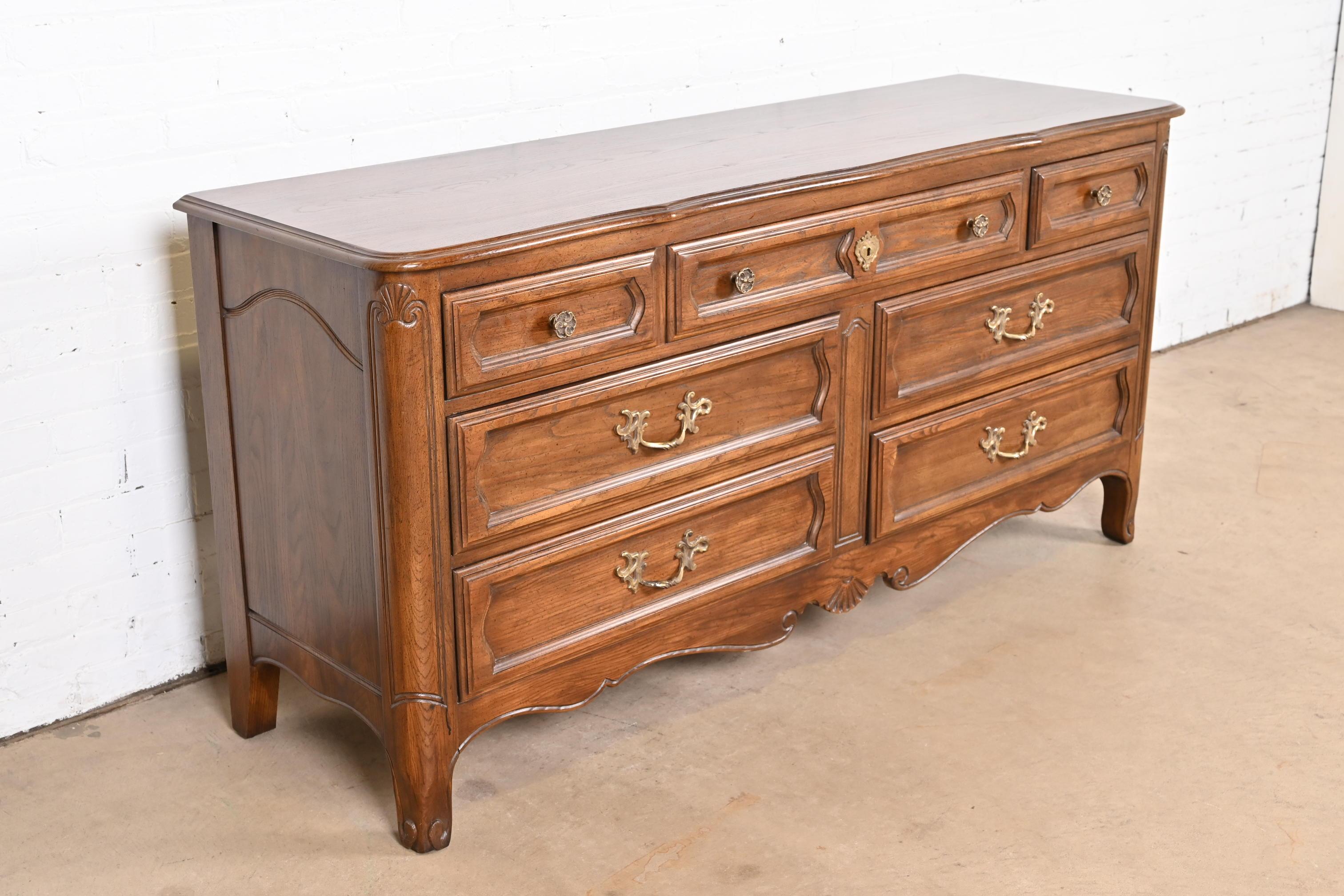 An exceptional French Provincial Louis XV style dresser or credenza

By Davis Cabinet Co.

USA, Circa 1980s

Carved solid oak, with original brass hardware.

Measures: 66